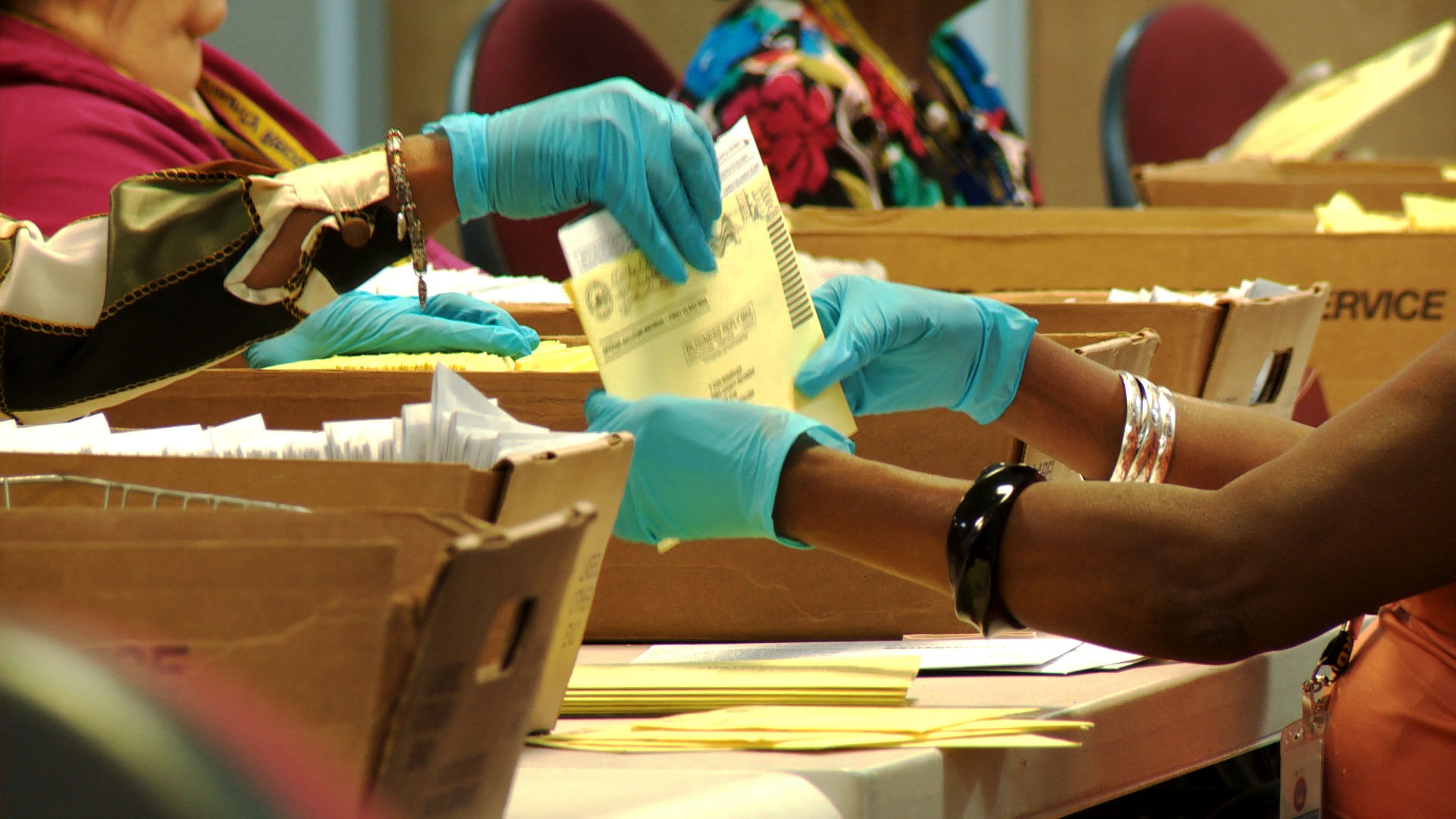 Election workers process mail ballots at the Pima County Elections Department. 