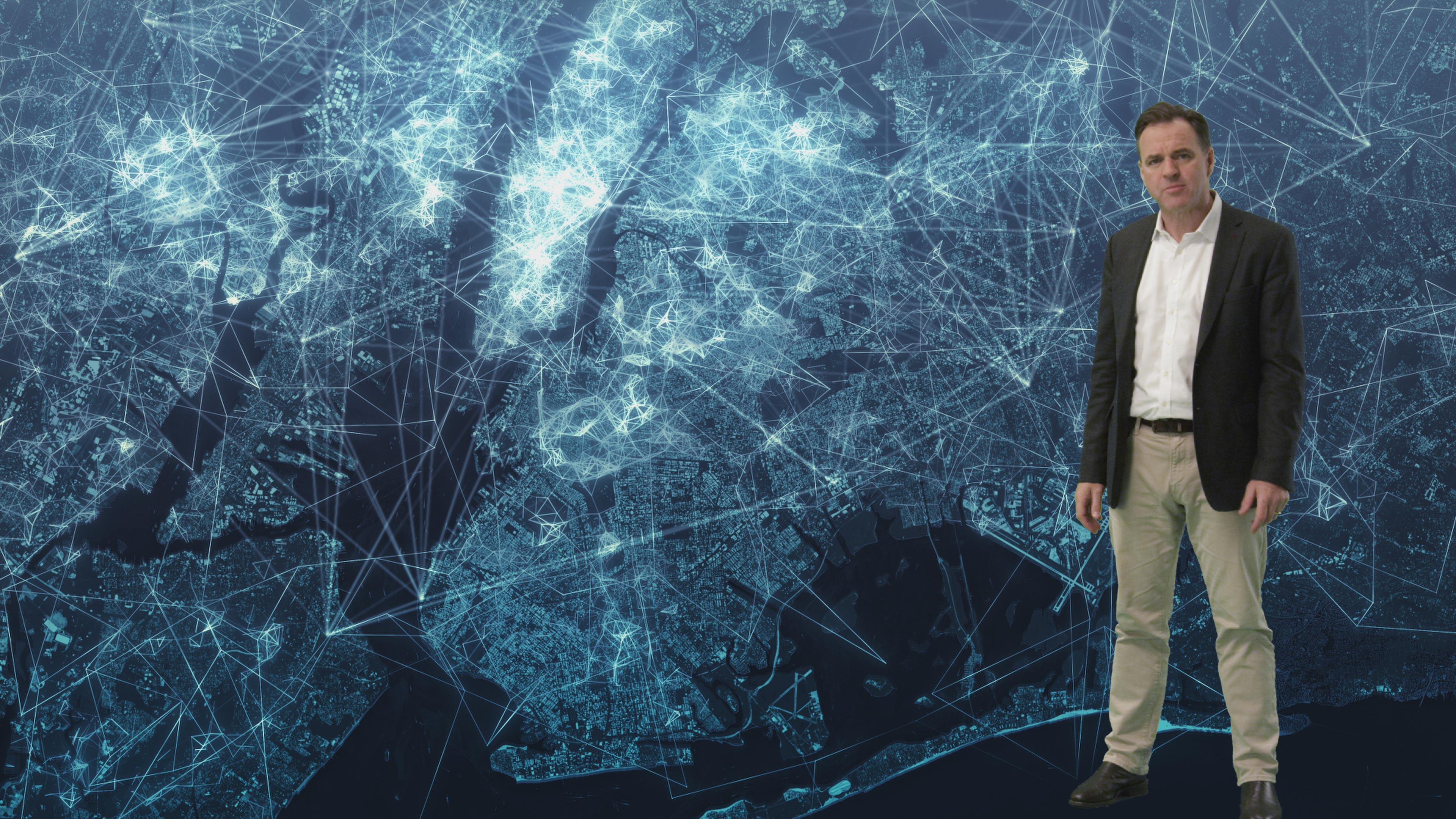 Niall Ferguson in front of Networld graphic of globe.