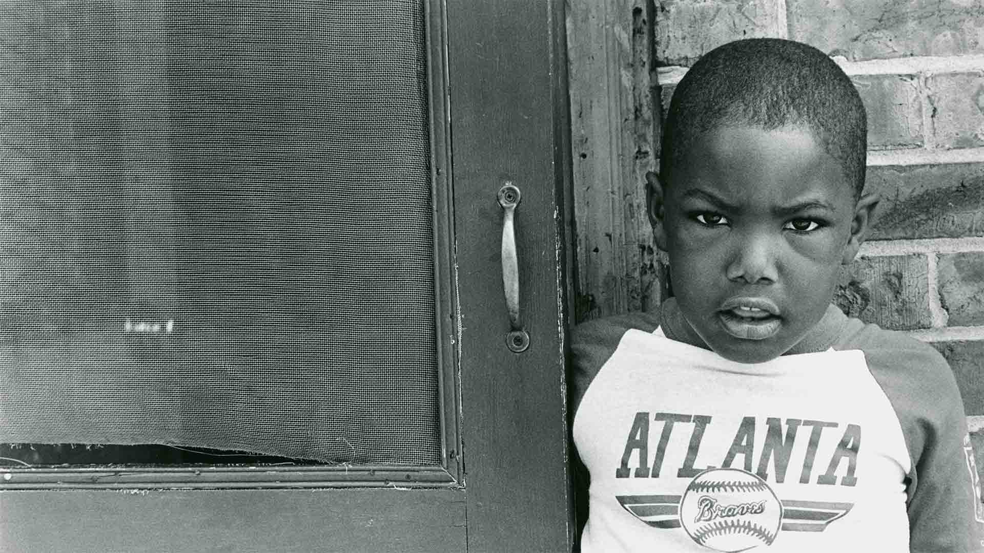 Brandon Thrasher stands in front of East Lake apartment. Atlanta, GA. Circa 1990. Use restricted after June 3, 2020.