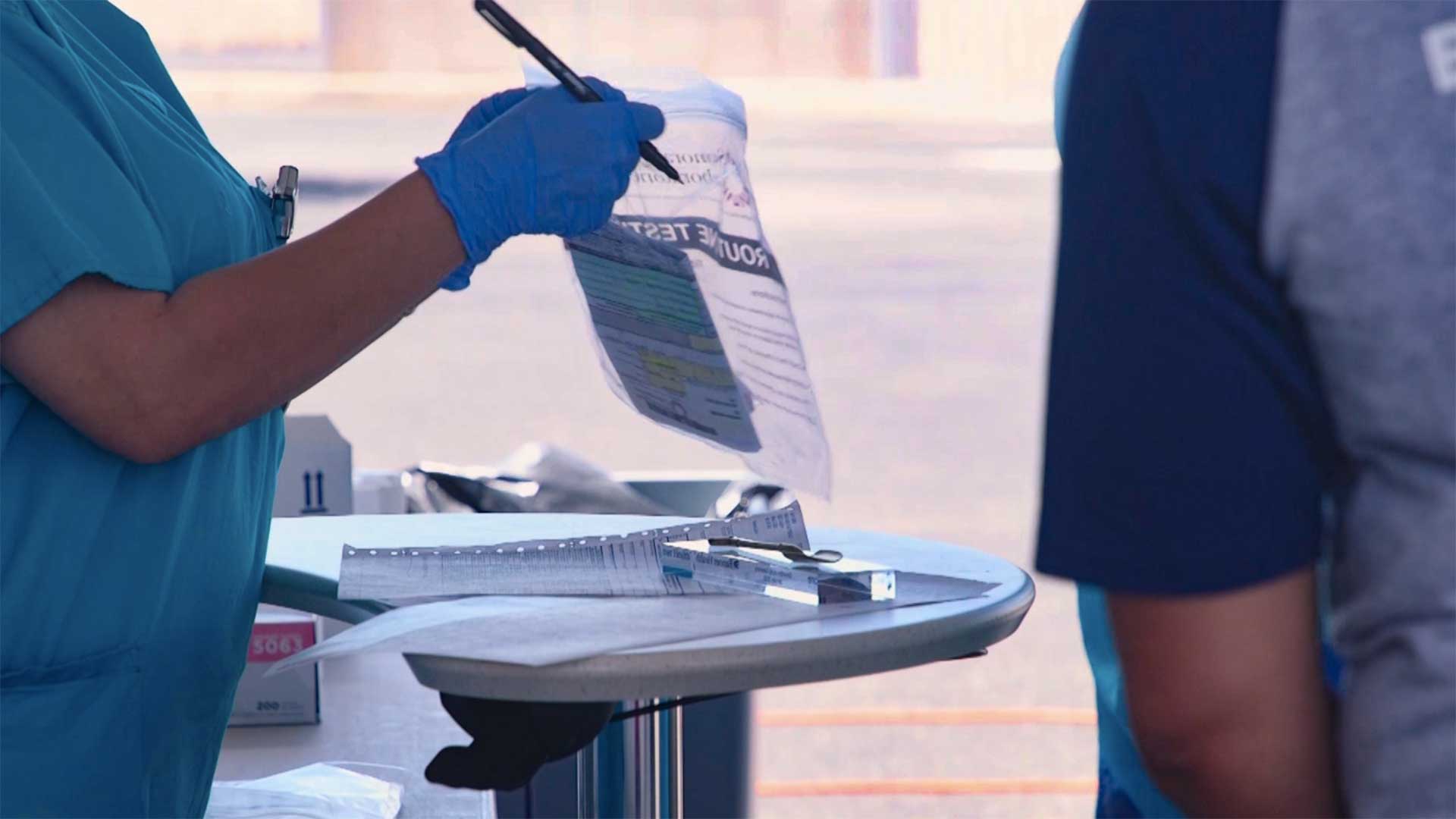 Banner Health workers seal a collection kit at a drive-thru testing site, in this undated still image from video. Banner says the testing is by  <a href="https://www.bannerhealth.com/patients/patient-resources/covid-19" target="_blank">appointment only</a>.