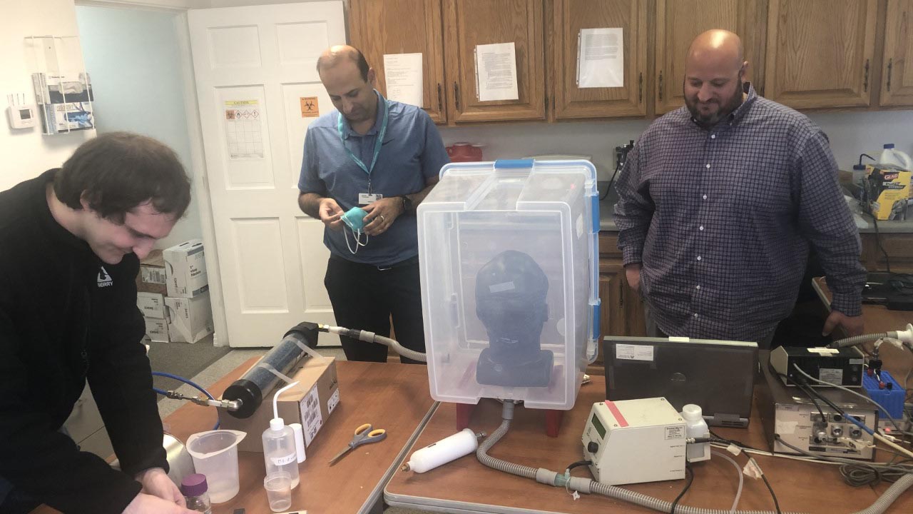 L-R researchers Connor Stahl, Sachin Chaudhary M. D., and Christopher Morton prepare to test 3D printed respirator mask at the University of Arizona