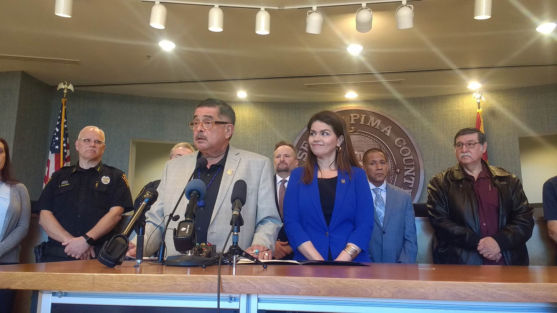 Surrounded by city and county officials, Pima County Supervisors Chairman Richard Elías and Tucson Mayor Regina Romero speak to reporters at a March 9, 2020 news conference about the local response to the spread of the novel coronavirus, which causes COVID-19.