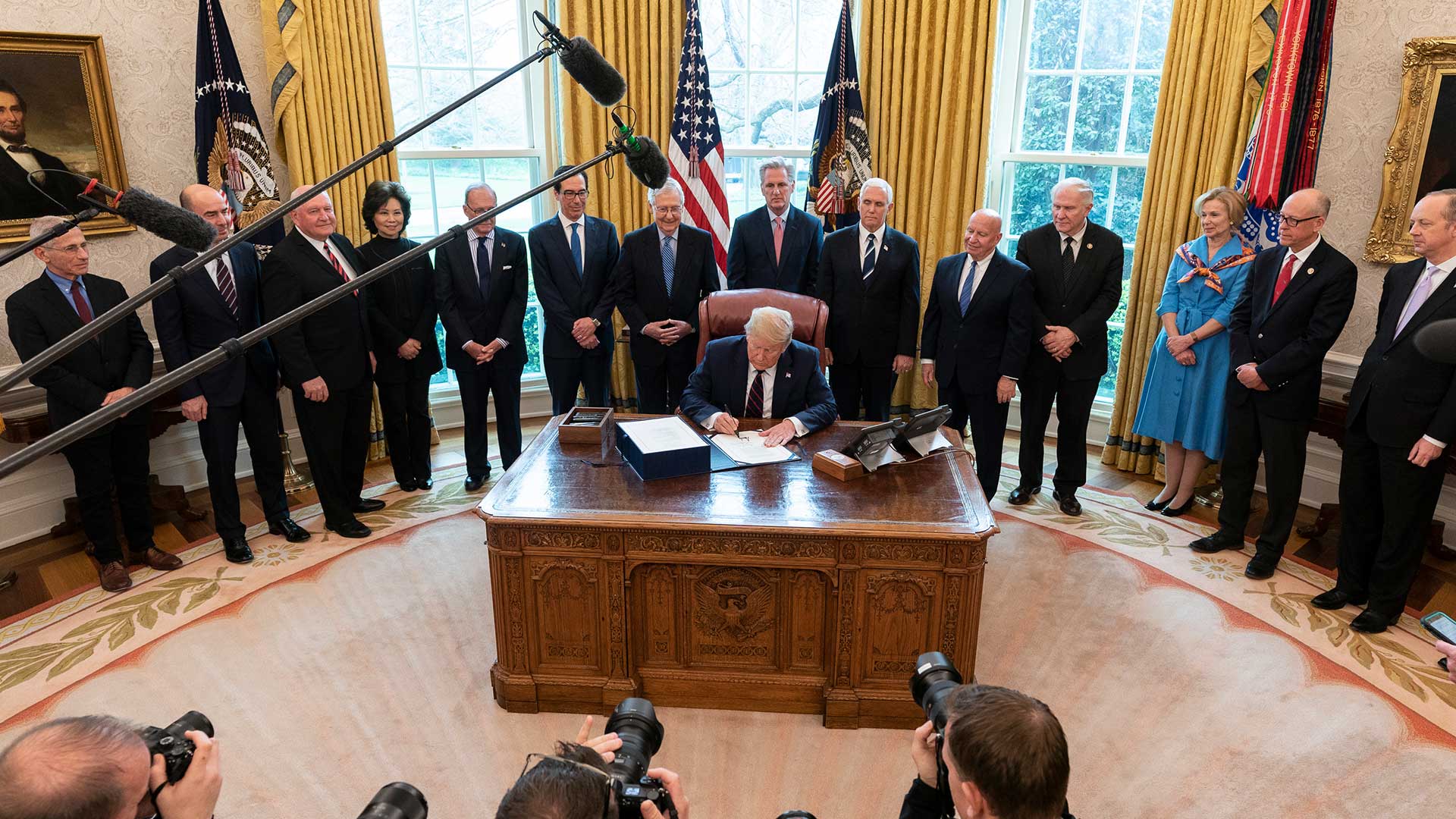 President Trump signs the $2.2 trillion COVID-19 relief package, March 27. DACA recipients in Arizona say it fails to protect mixed immigration status families during a crucial time.