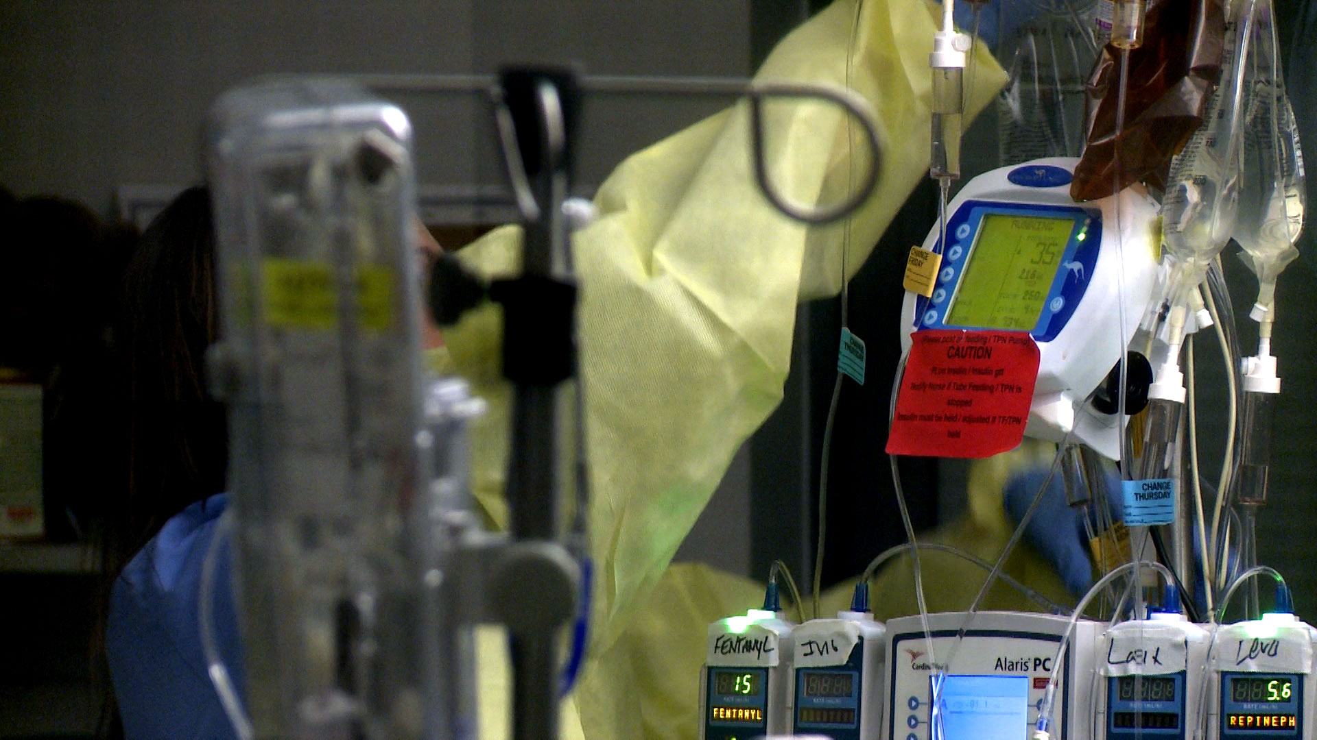 File image of a health care worker adjusting an IV bag. 