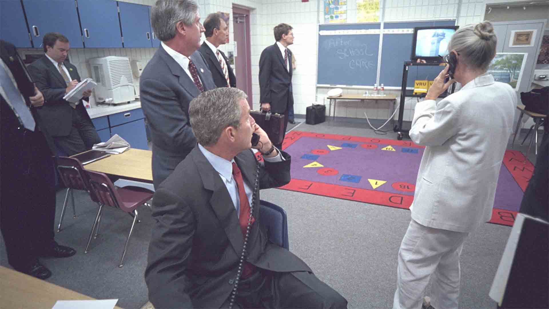 President George W. Bush with staff in a holding room at the Emma E. Booker elementary school in Sarasota, Florida. The president talks on the phone with Condoleezza Rice about a plane that crashed into the North tower of the World Trade Center at 8:48 a.m. on September 11, 2001.