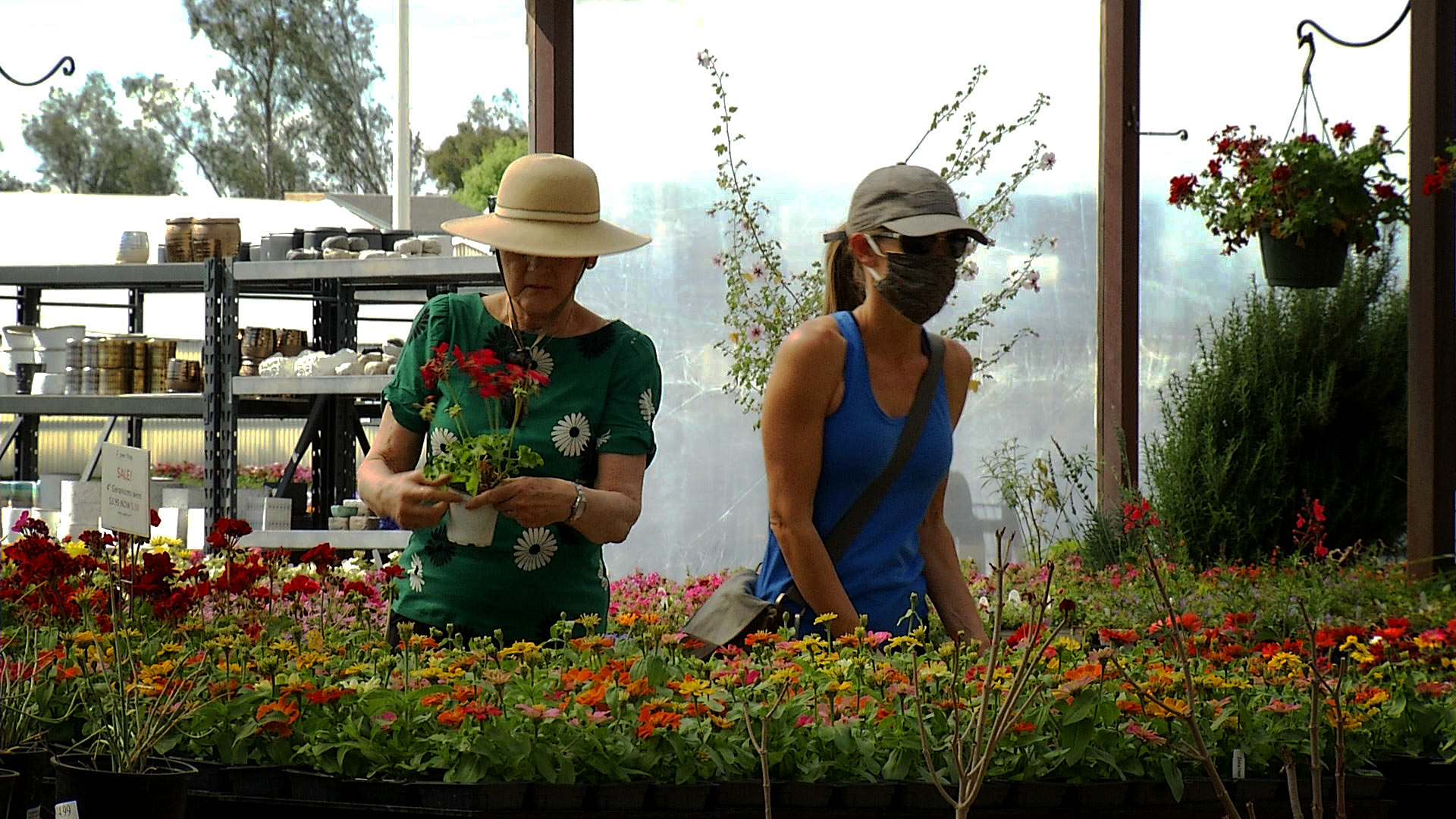 Customers at Green Things in Tucson shop for plants on April 7, 2020. One customer wears a face mask. The nursery is considered an essential business in Arizona. 
