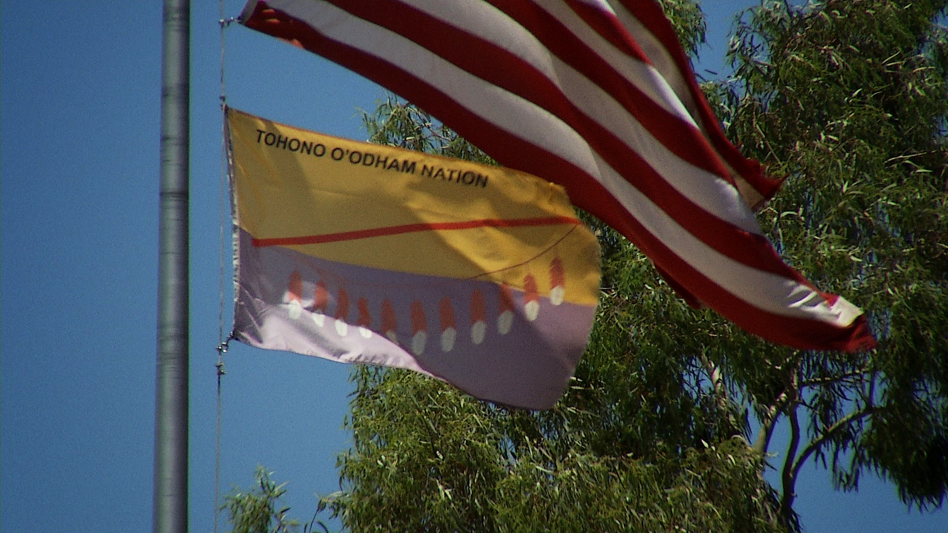 A flagpole flies the flag for the Tohono O'odham Nation and the American flag on the nation. 