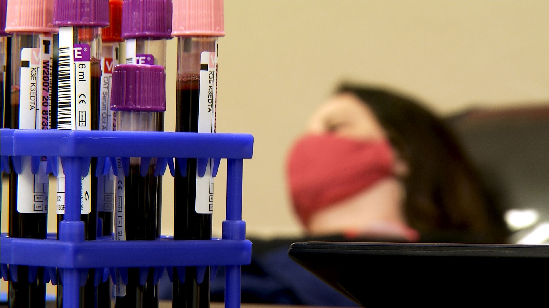 Blood samples in a tray at an American Red Cross blood donation center in Tucson on May 1, 2020. In the background, a woman who recovered from COVID-19 waits to donate her plasma as part of the organization's new convalescent plasma program. 