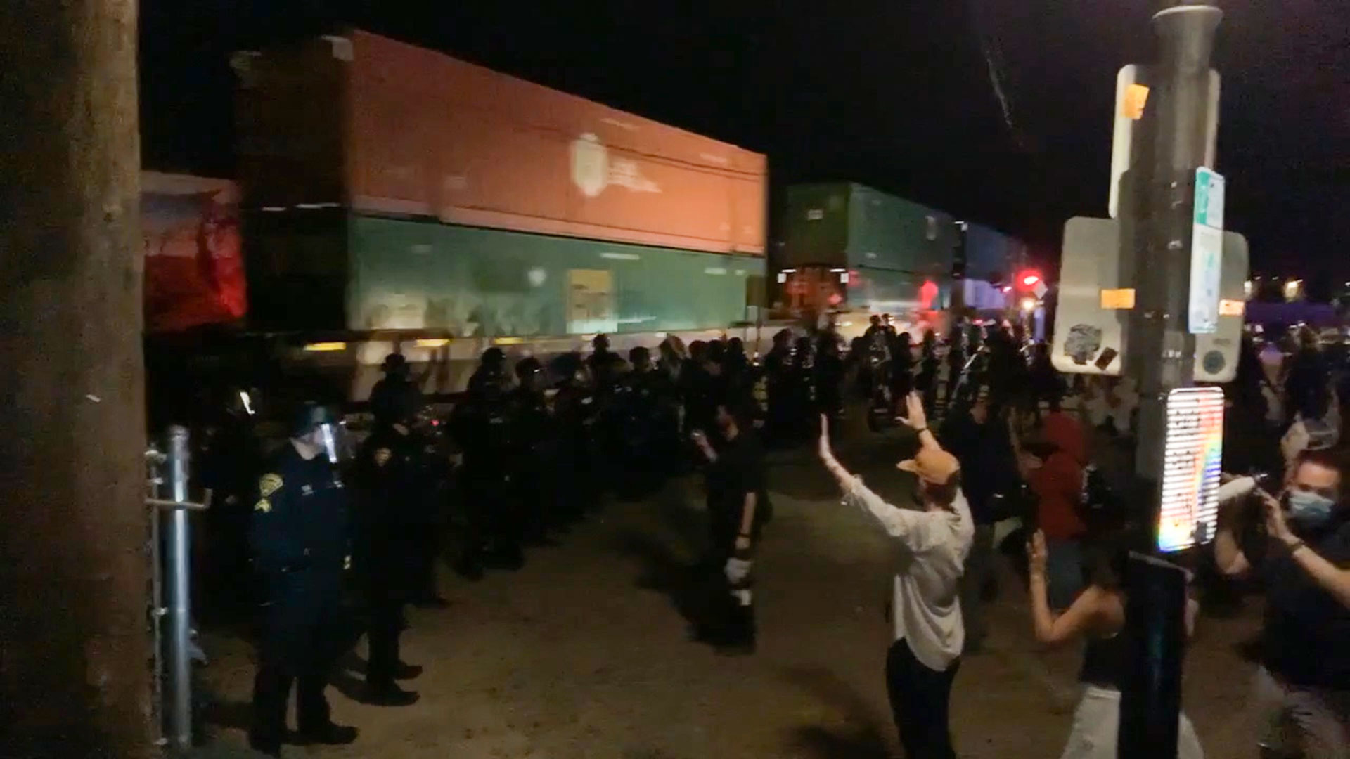 As a train passes, marching demonstrators raise their hands after being stopped by police near downtown Tucson Saturday night in this still image from a video, as protests over the death of George Floyd spread across the country.