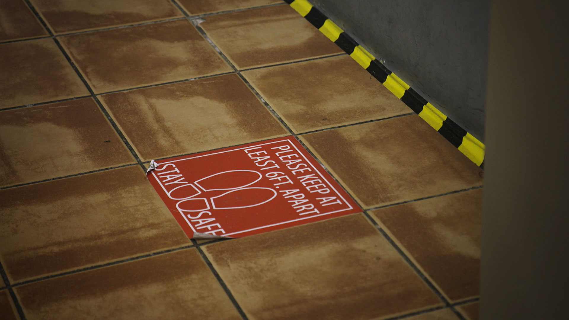 A sticker on the ground notifies customers where to stand in order to maintain social distancing at Sam Levitz Furniture Warehouse. May 2020. 