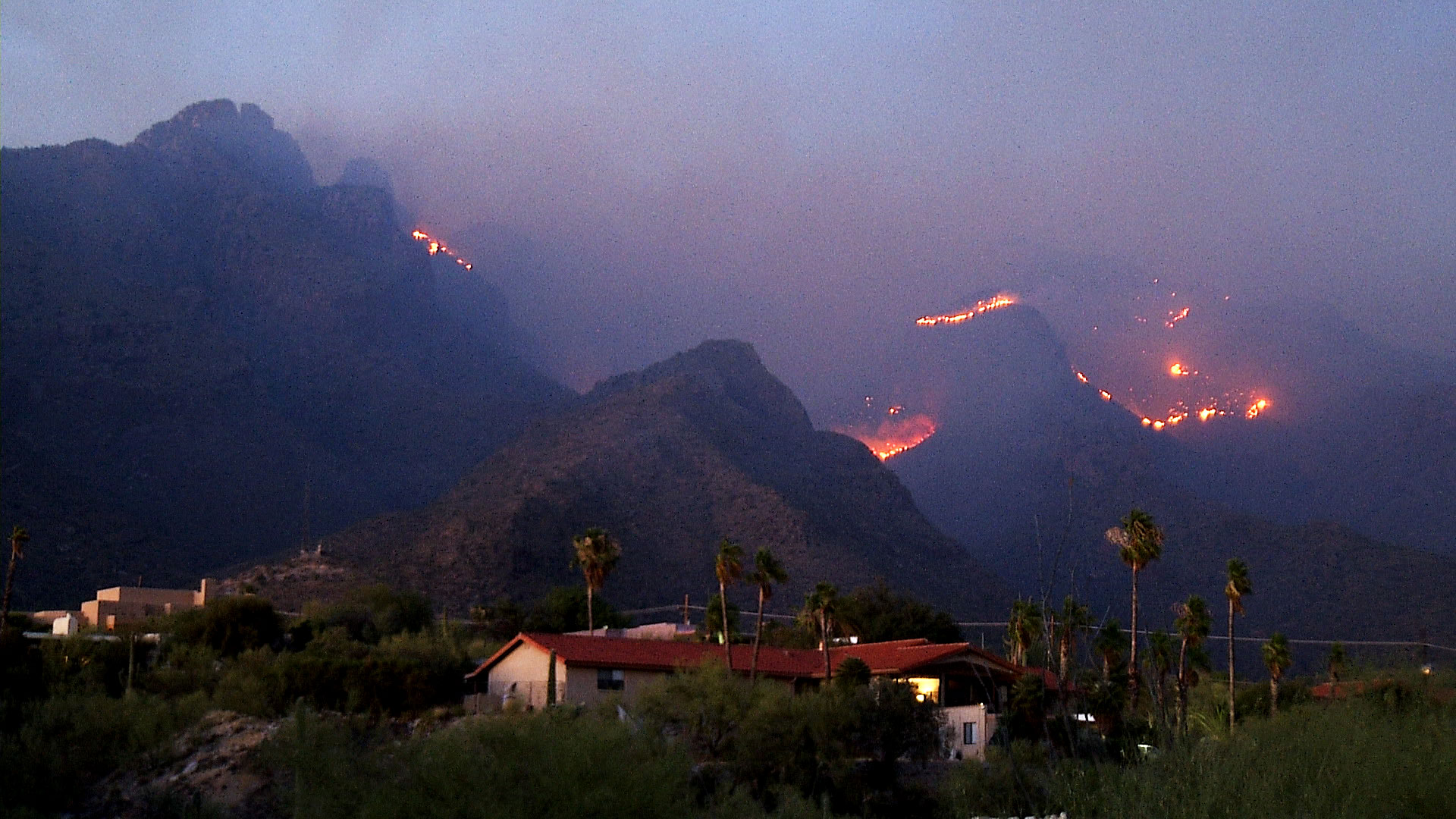 With residences in the foreground, the Bighorn Fire burns in the Santa Catalina Mountains on June 10, 2020.