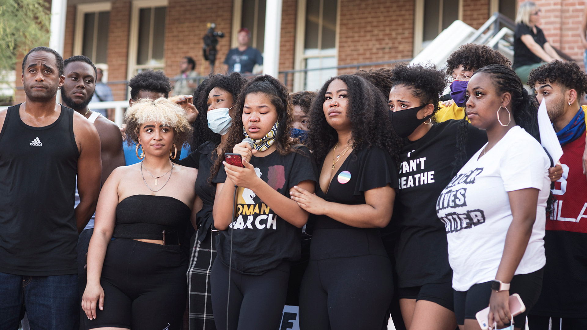 Speakers gather around sisters Jasmine and Janel Drummer as Janel reads an emotional account of her experiences during the March for Justice Tucson event at the University of Arizona campus on June 4, 2020.