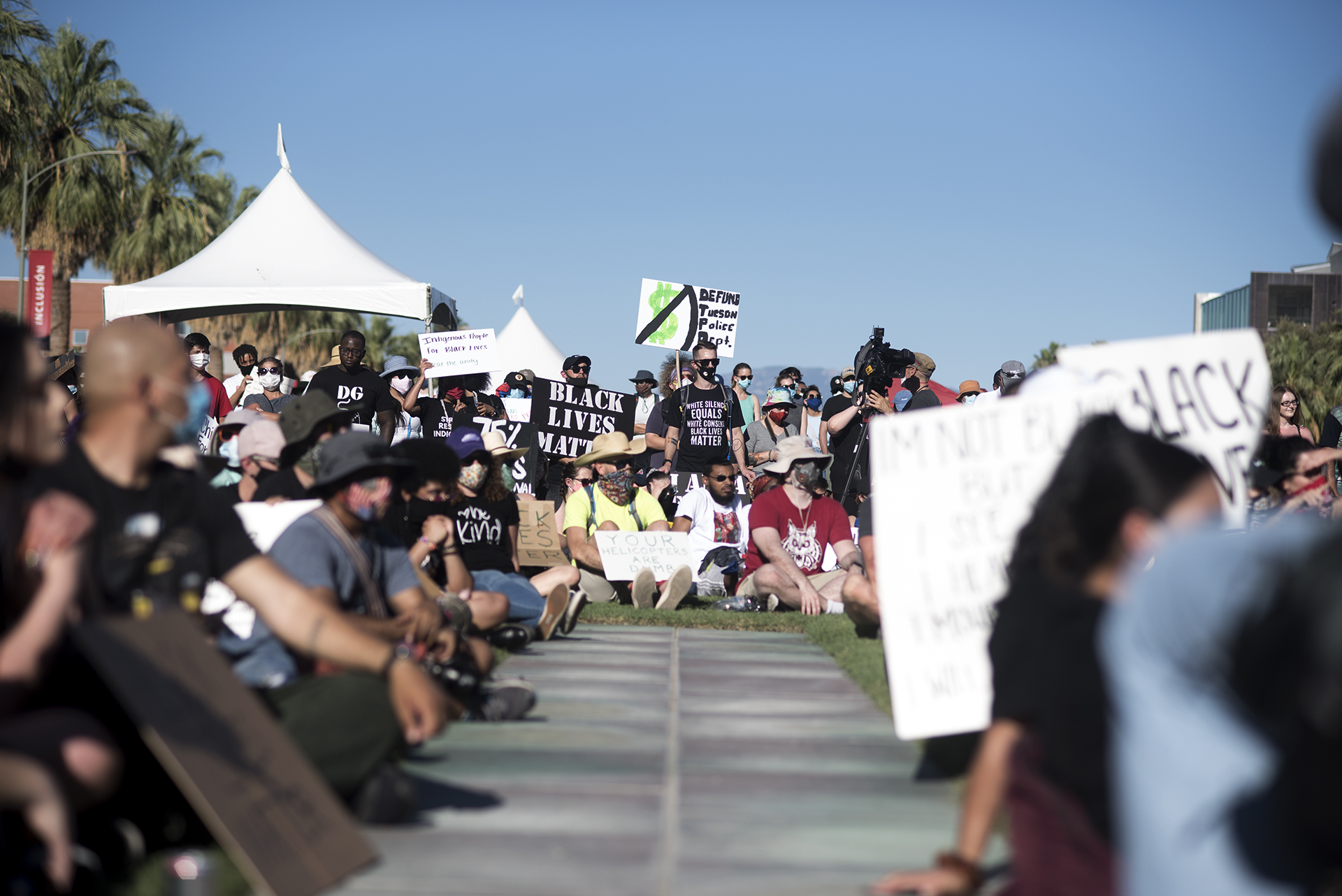 Demonstrators hold signs against police brutality and violence during the Black Lives Matter Tucson: Celebration of Black Lives on the University of Arizona campus.