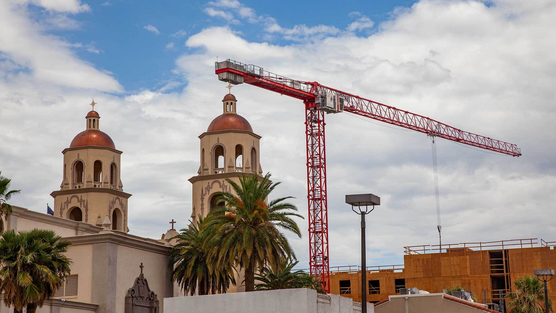 A crane rises above the construction site for a new Hilton Hotel across from the Cathedral St. Augustine.