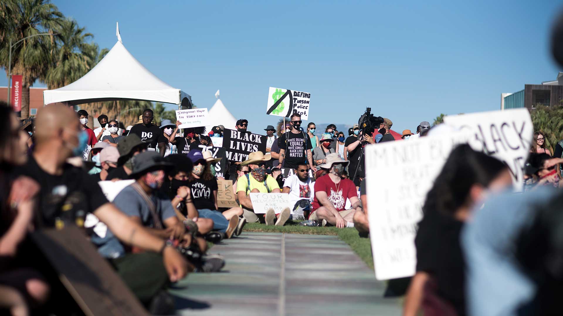 Demonstrators hold signs against police brutality and violence during the Black Lives Matter Tucson: Celebration of Black Lives on the University of Arizona campus on June 6, 2020.
