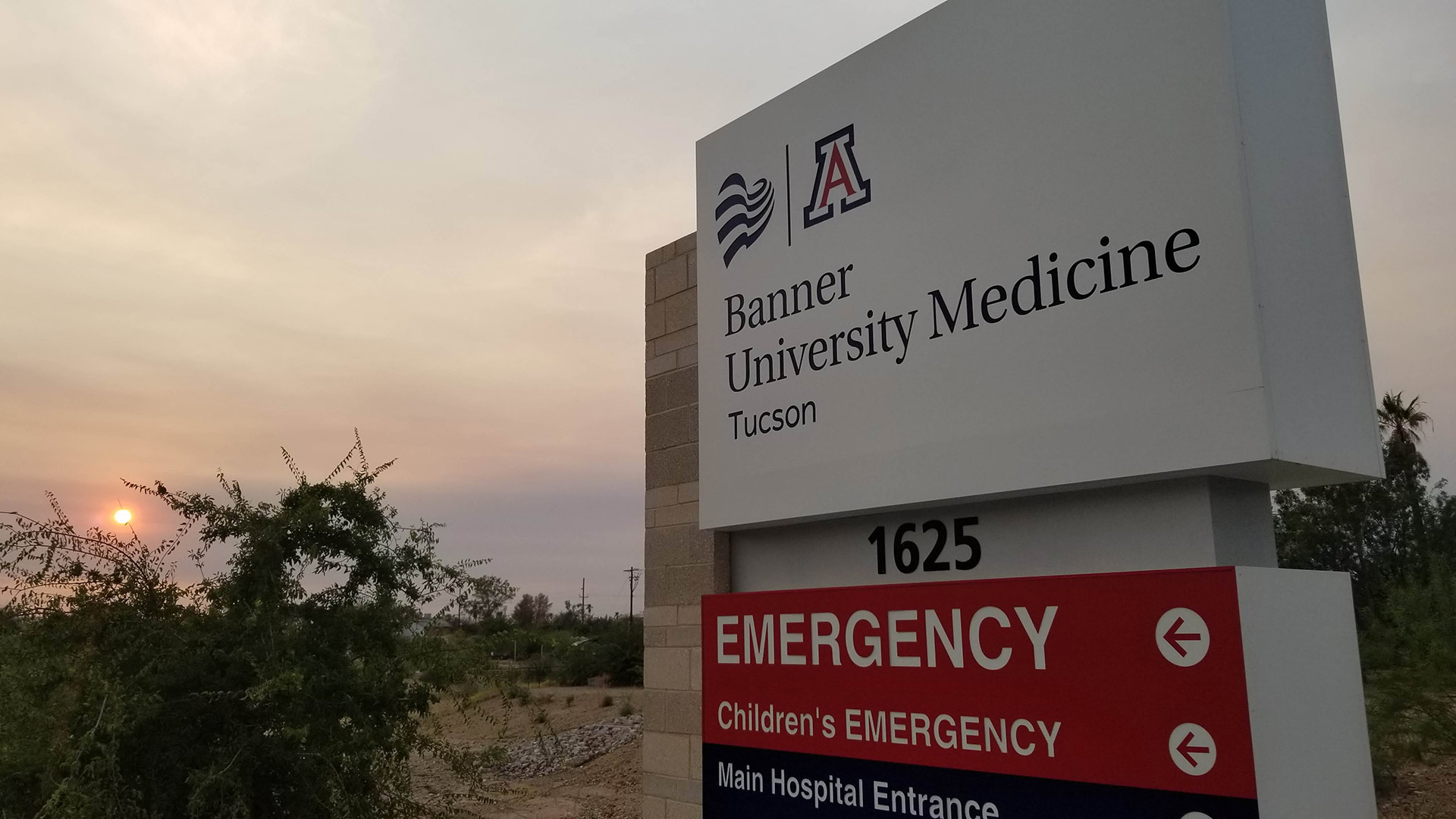 A sign outside the east entrance to Banner University Medicine directing visitors and patients to the emergency room.