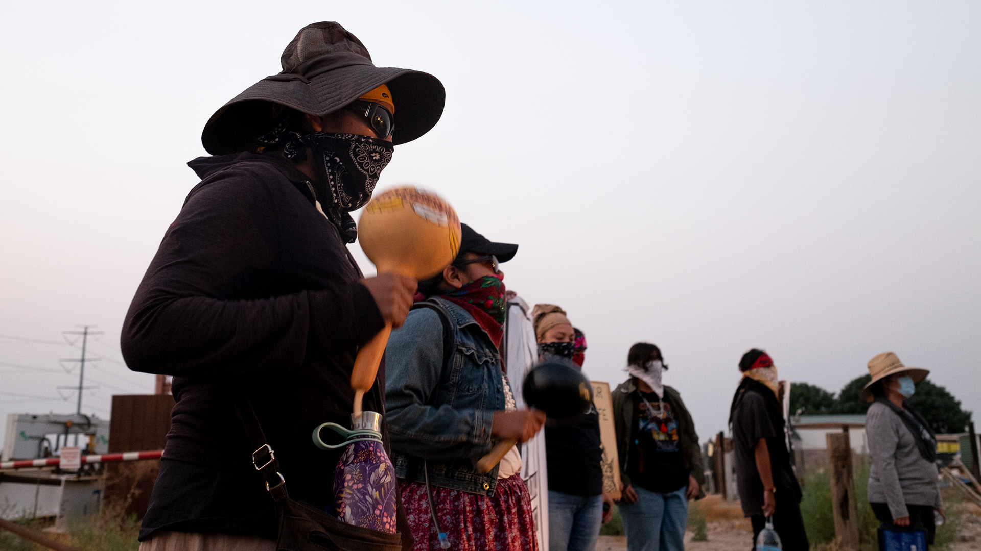 An Indigenous demonstrator shakes a rattle during the early morning protest in Coolidge on Aug. 26, 2020.