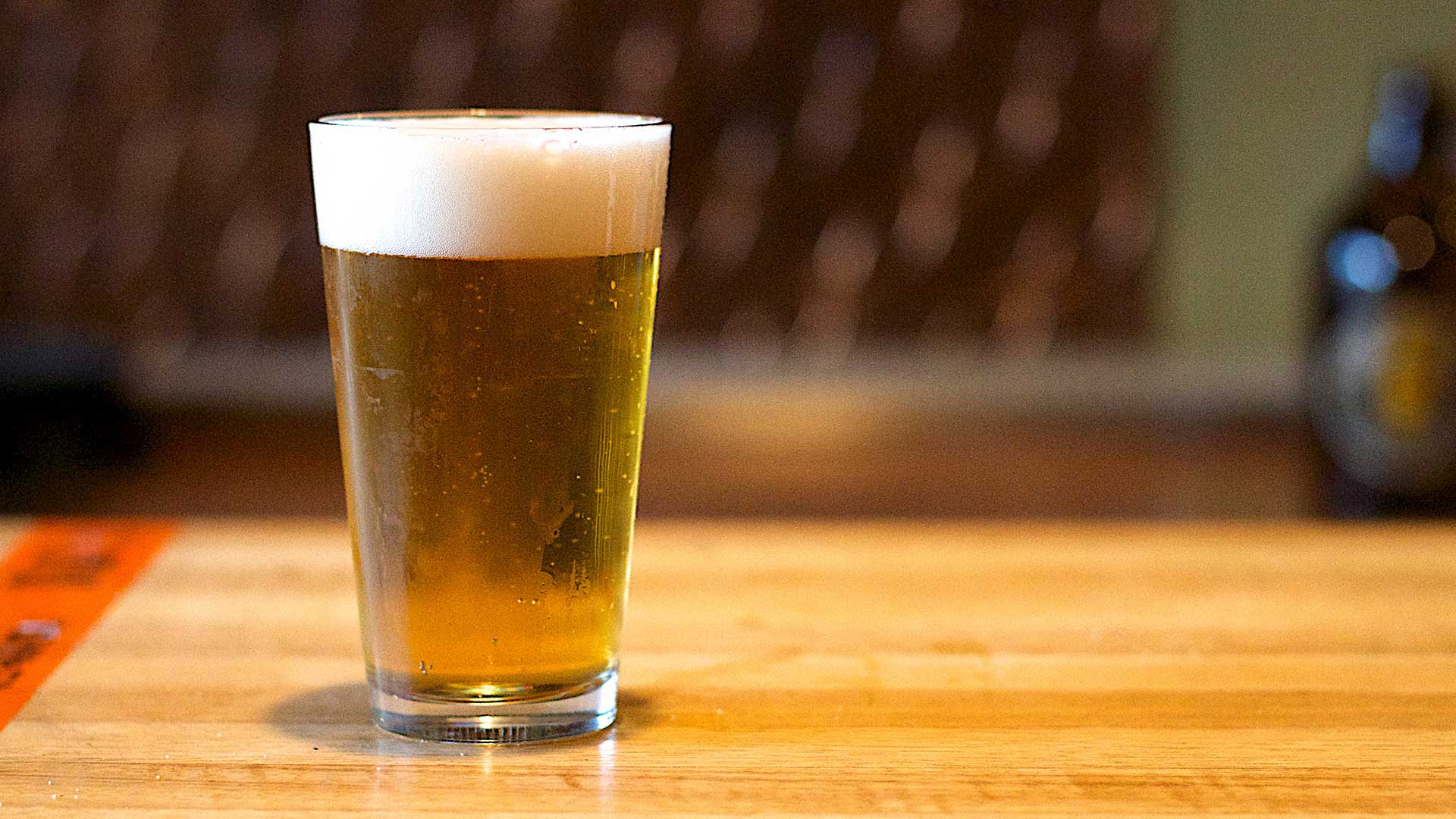 A glass of beer on a table.