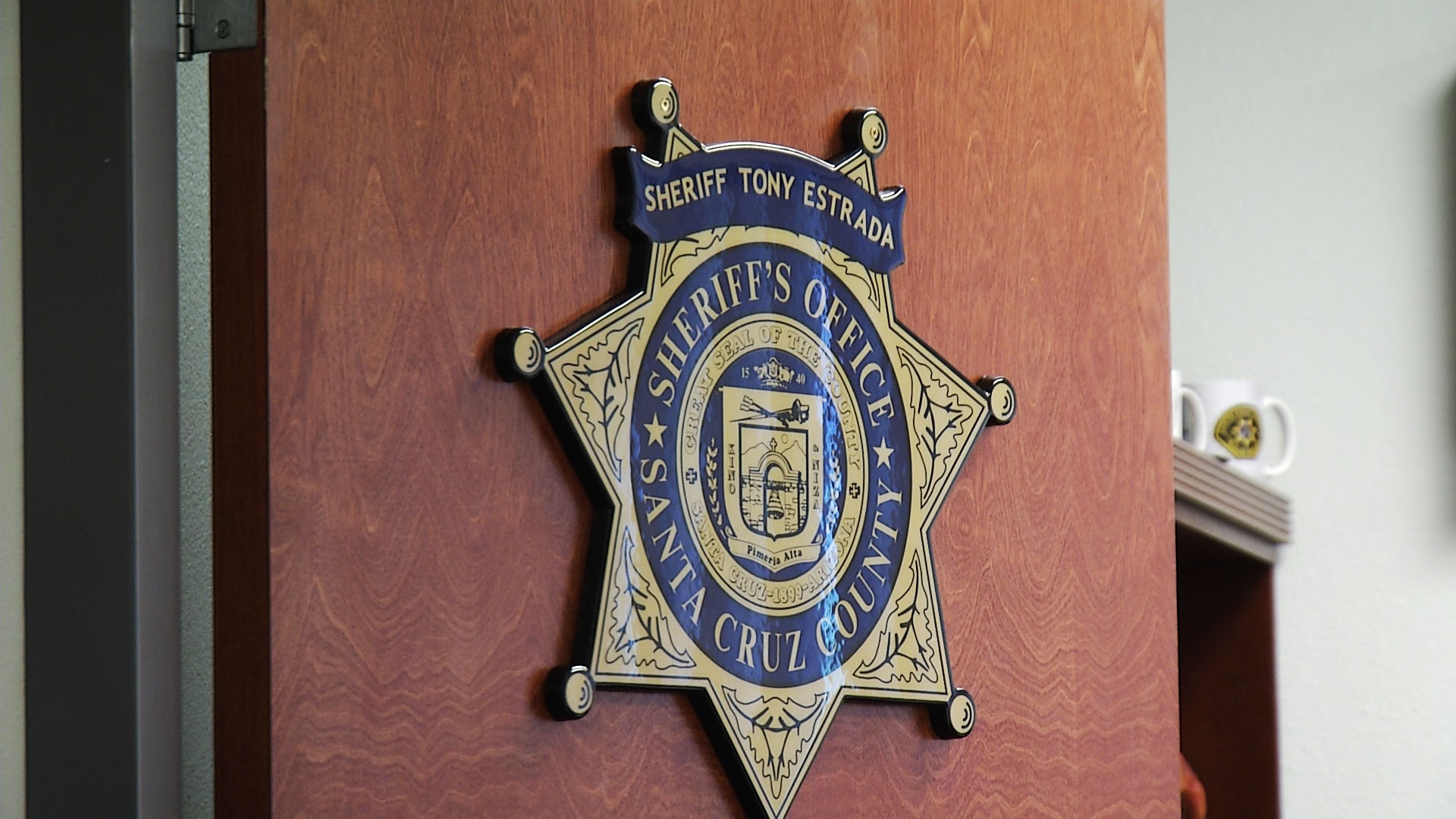 A sheriff's star sign hangs on the door of Santa Cruz County Sheriff Tony Estrada's office at the department in Nogales. 