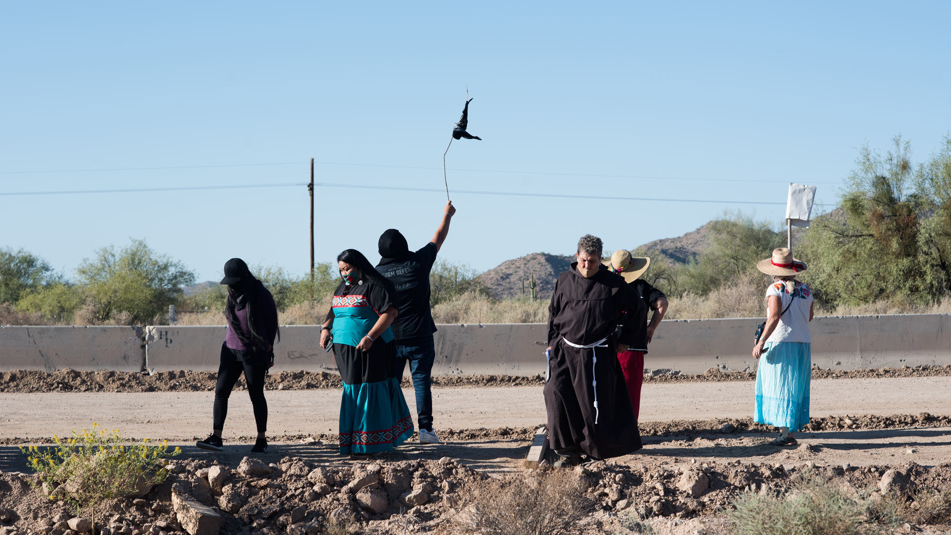 Tribal members and supporters gather in front of the construction line to wave down O'odham runners coming from Sonora ahead of a cross-border ceremony at Quitobaquito Springs on Sept. 27, 2020.