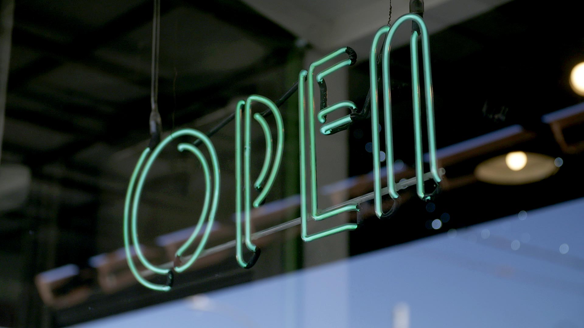 A neon open sign is illuminated in the storefront of a business on North 4th Avenue. January 2021. 