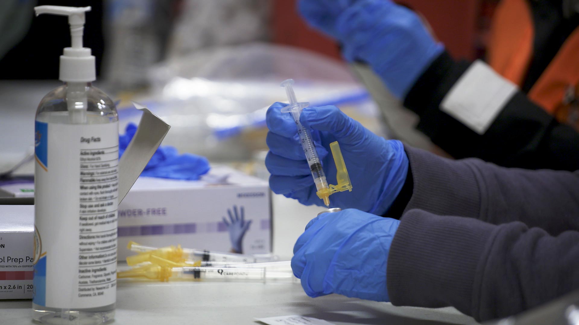 A health care worker prepares doses of the COVID-19 vaccine at a vaccination event in Globe on March 13, 2021. 