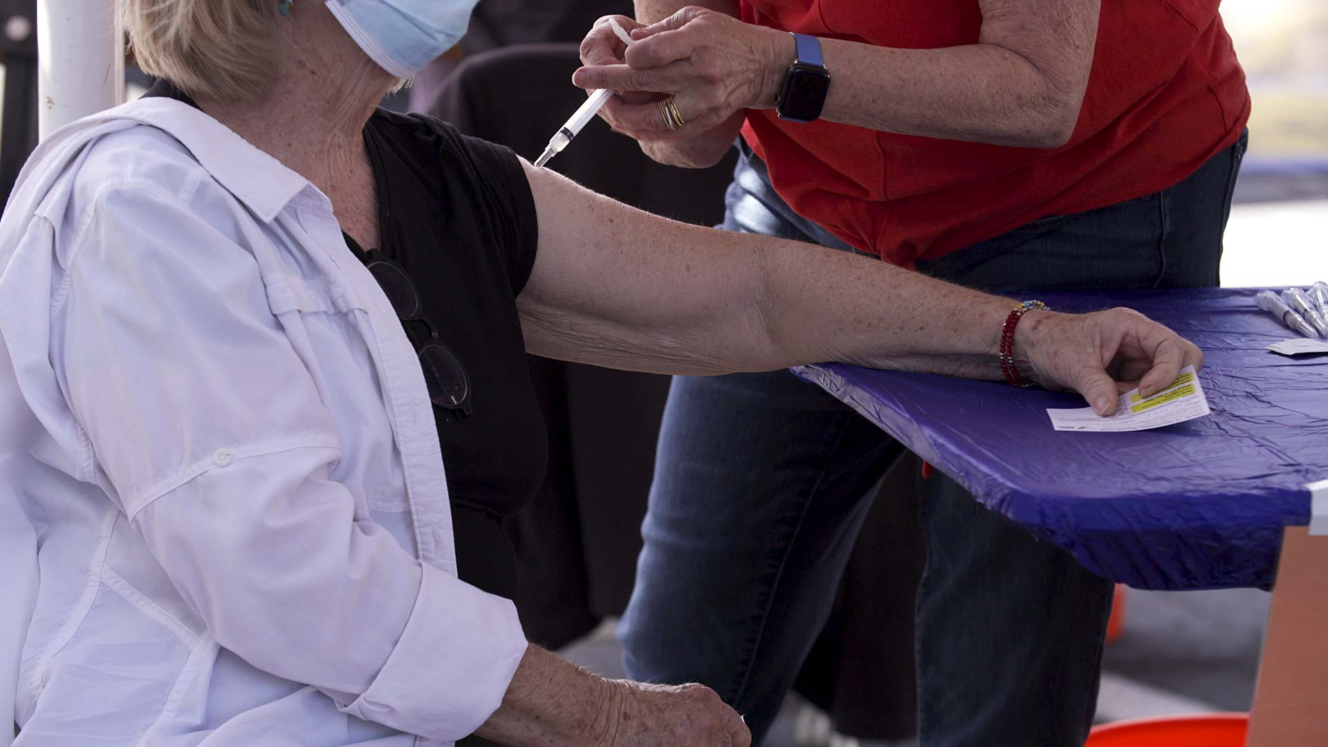 A woman receives a COVID-19 vaccine during a mobile event run by Pima County and Tucson Medical Center outside St. John the Evangelist Catholic Church on March 6, 2021. 