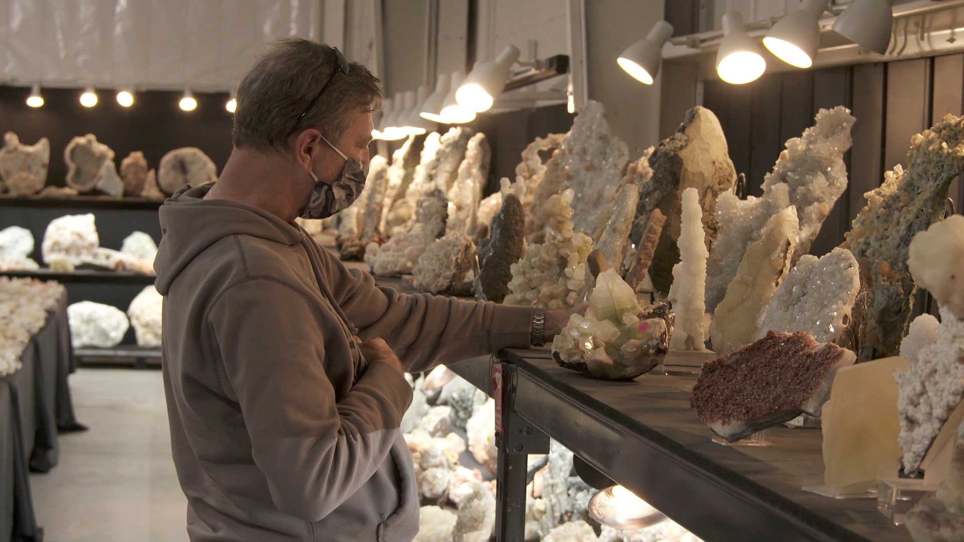 Mark Young examines a gem at Superb Minerals. The company is temporarily in Tucson for the Tucson Gem, Mineral and Fossil Showcase, despite the event featuring significantly fewer vendors due to the pandemic. March 2020. 
