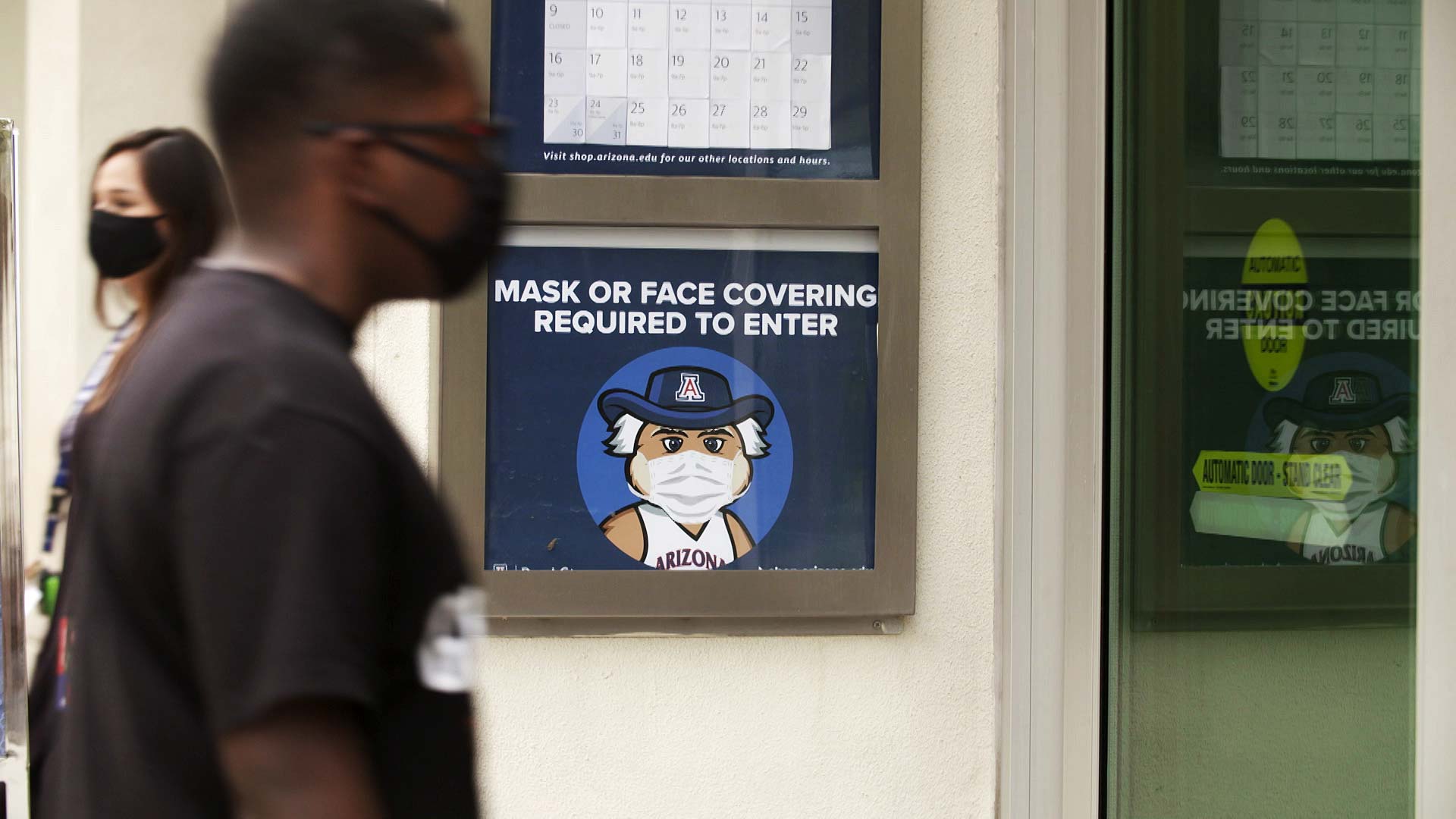 A sign outside of the University of Arizona bookstore reminds visitors that masks are required to enter. 