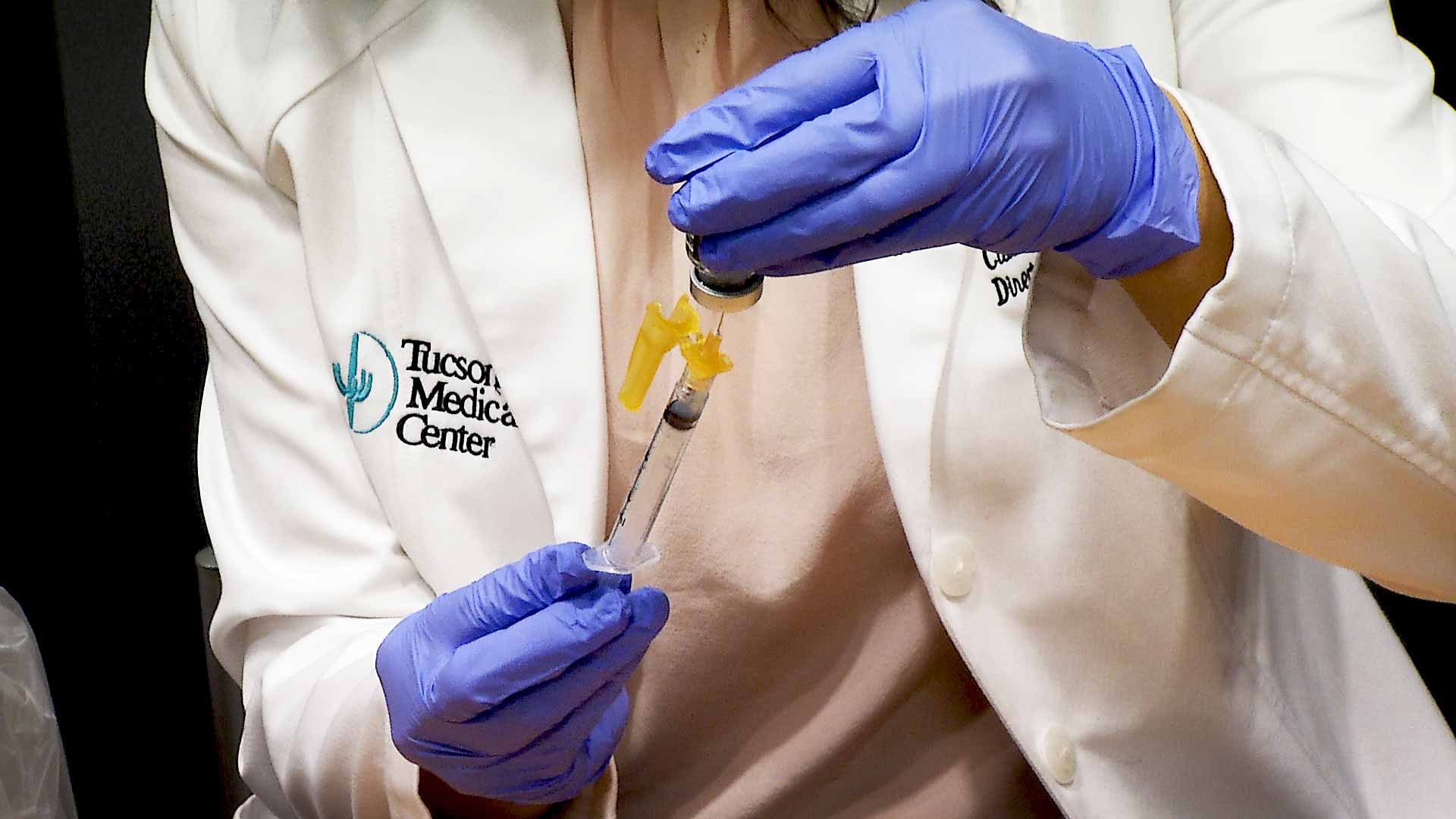 A health care worker at Tucson Medical Center fills a syringe with a dose of the COVID-19 vaccine. January 2021. 