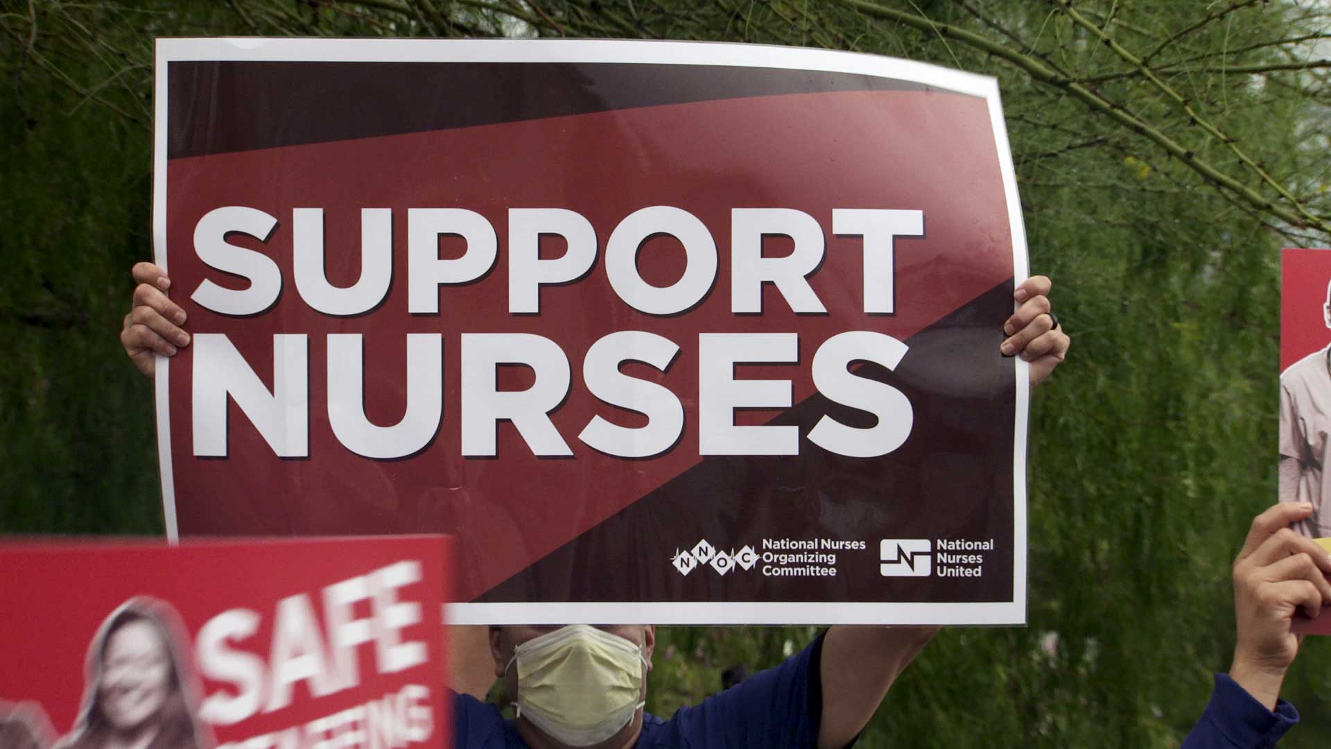 A nurse holds up a sign outside of St. Mary's Hospital where nurses staged a demonstration to call out staffing shortages on July 14, 2021. 