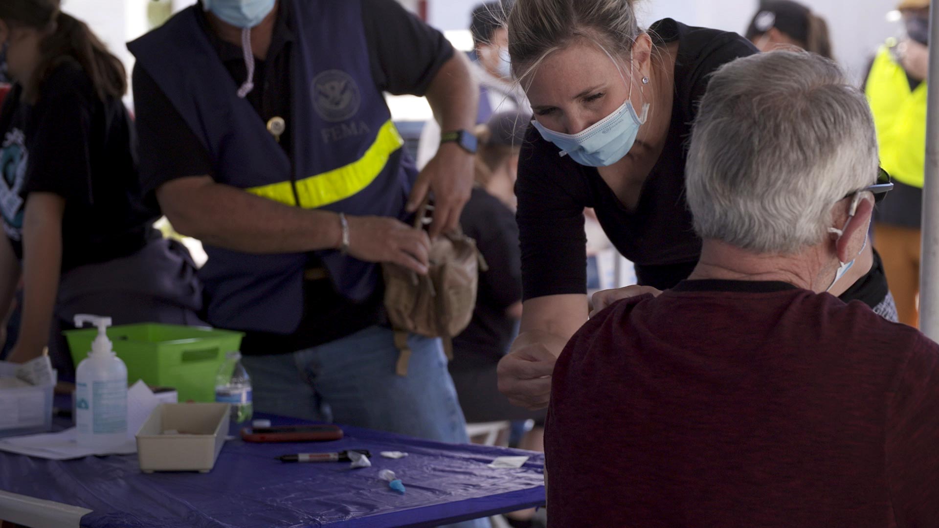 A health care worker administers a COVID-19 vaccine on a man at St. John the Evangelist Catholic Church in Tucson. March 2021.