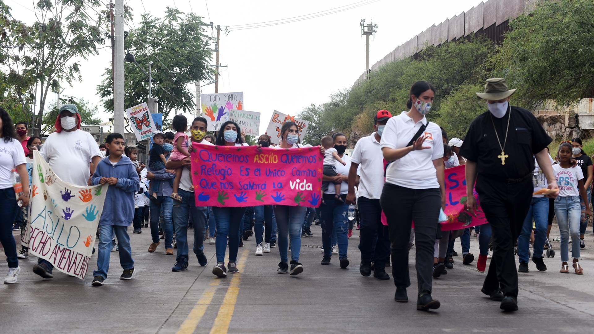 Migrants march toward the Deconcini Port of Entry in Nogales, Sonora in a demonstration asking President Joe Biden to restore the U.S. asylum process.