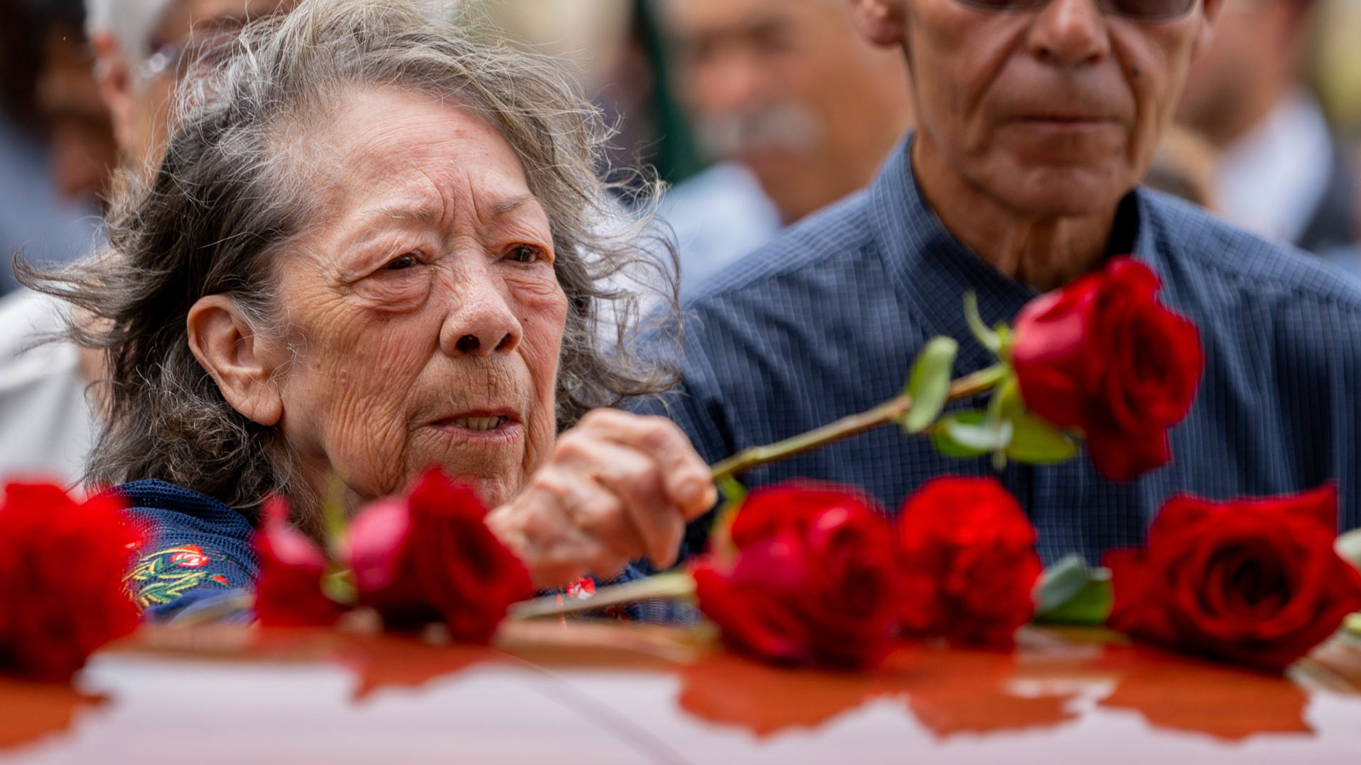 Connie Cintron places a red rose on the casket of her brother, Pvt. Felix Yanez, at South Lawn Cemetery in Tucson on Sept. 3, 2022.