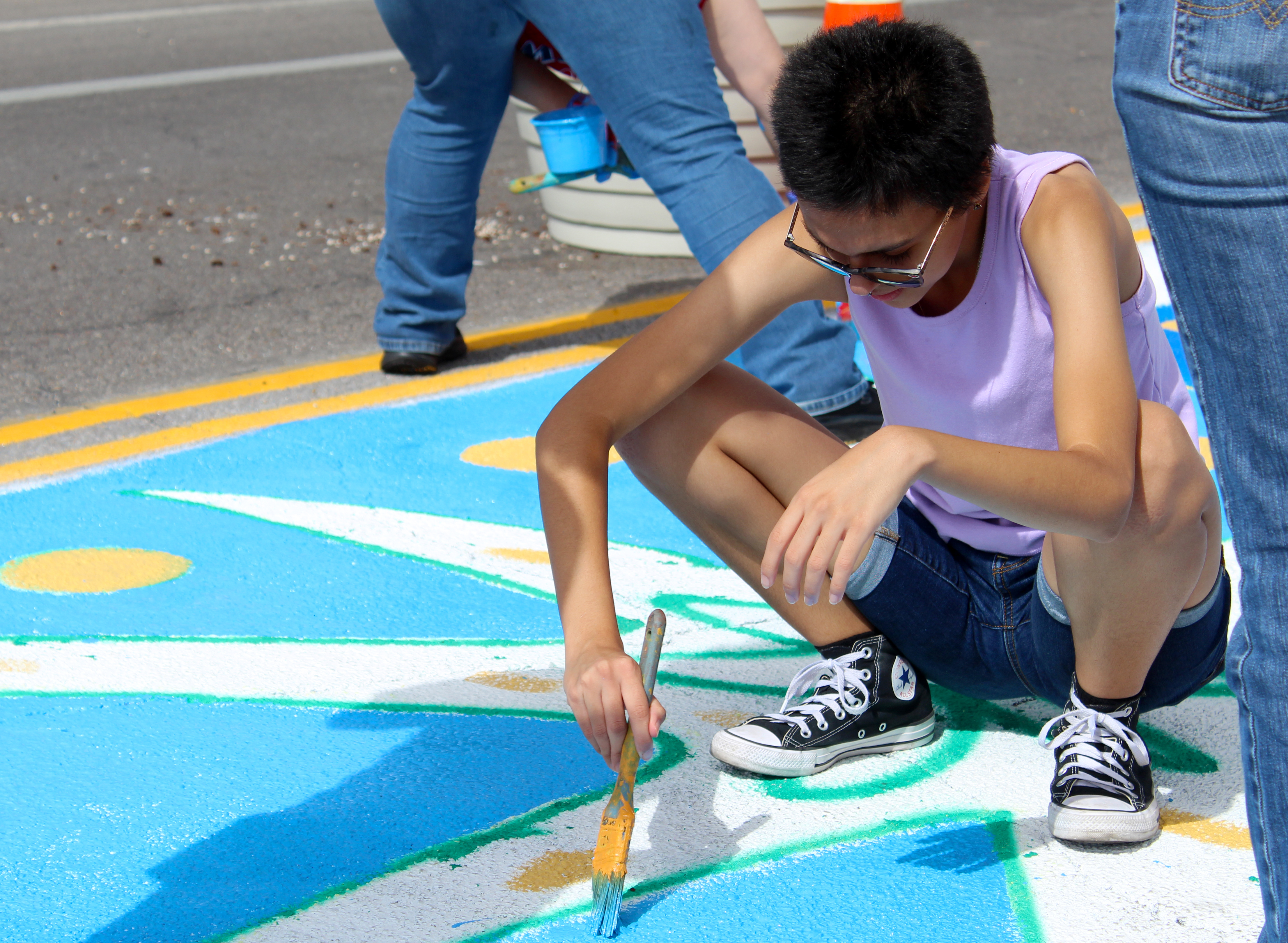 Volunteer painting on the ground.