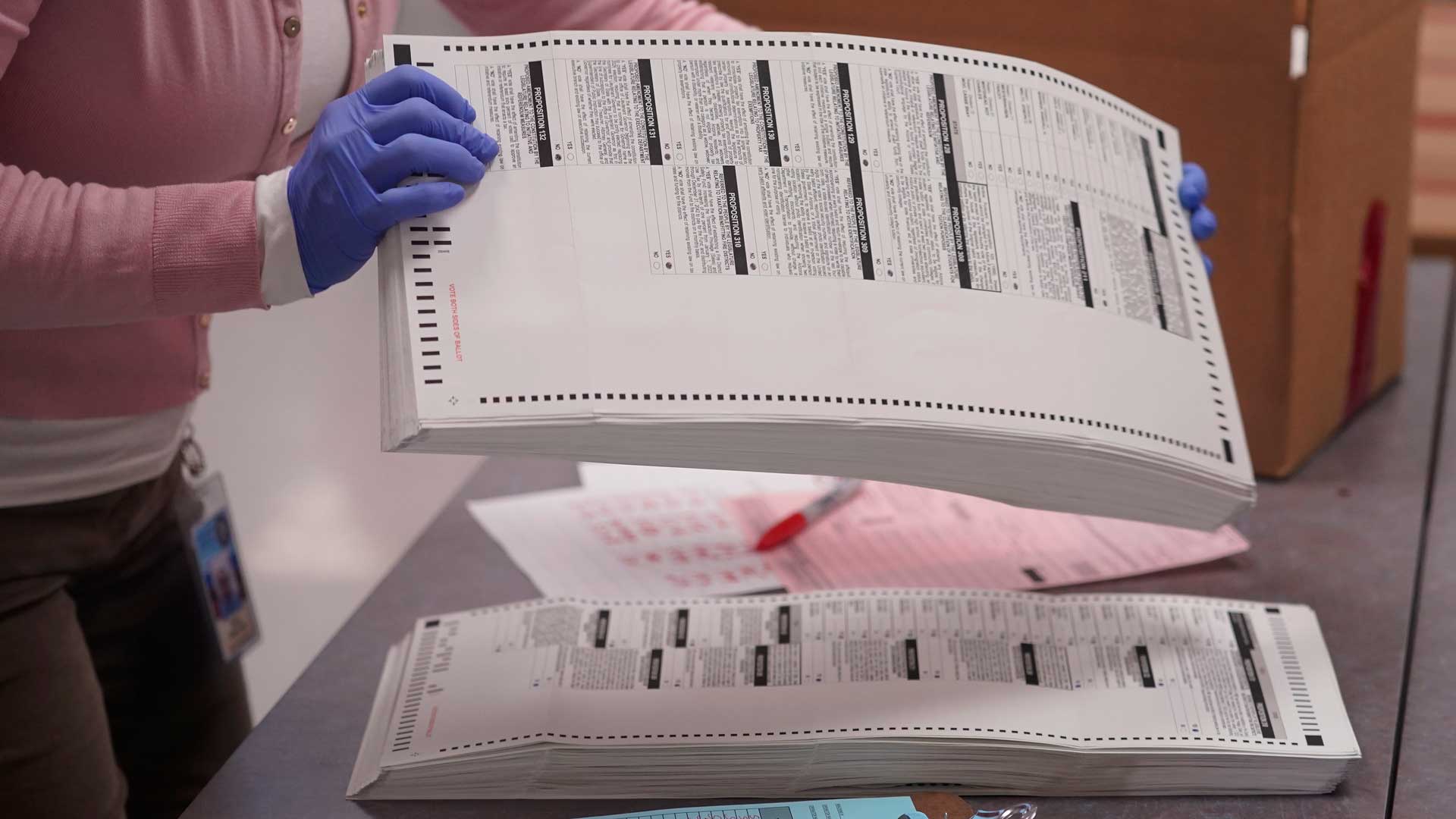 An election worker gathers tabulated ballots to be boxed inside the Maricopa County Recorders Office, Thursday, Nov. 10, 2022, in Phoenix. 