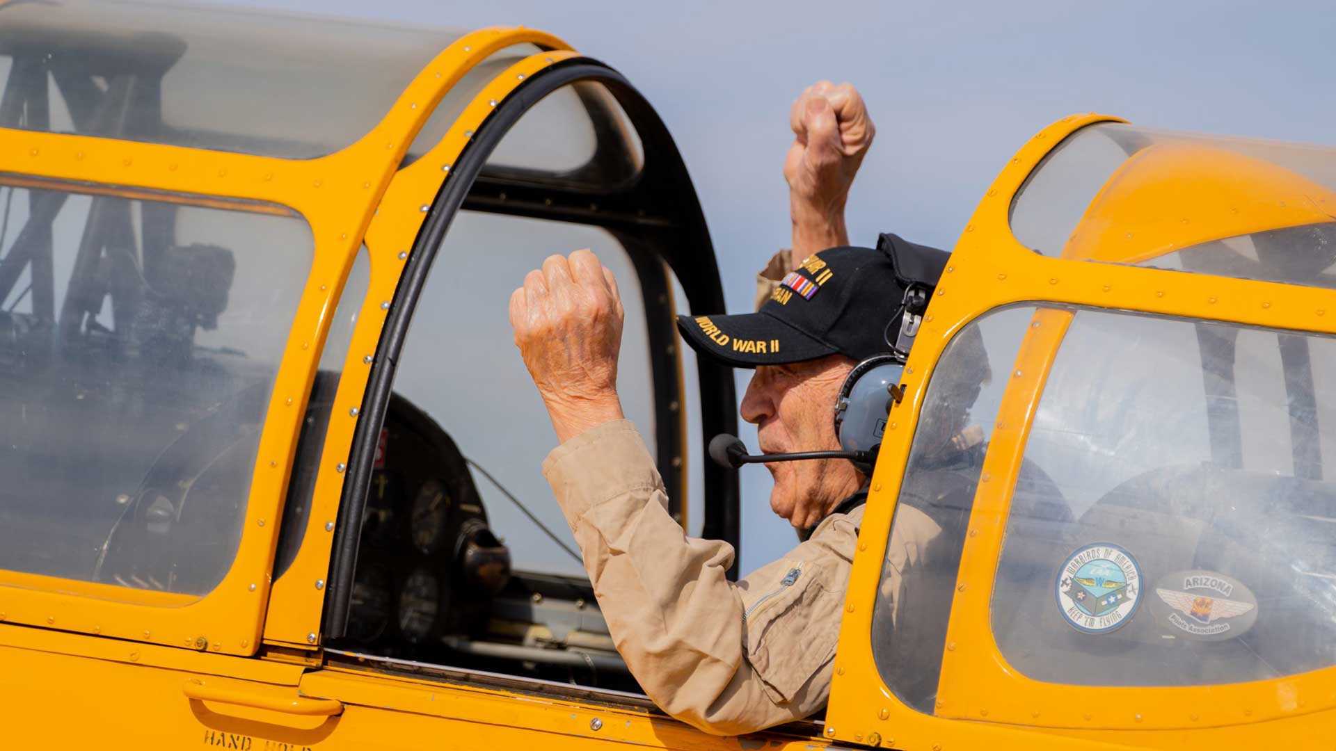 Centenarian Ted Giannone raises both hands in the air as he lands at Falcon Field Airport in Mesa on Oct. 30, 2022, after becoming Grounded No More’s 500th rider since 2016. (Photo by Samantha Chow/Cronkite News)