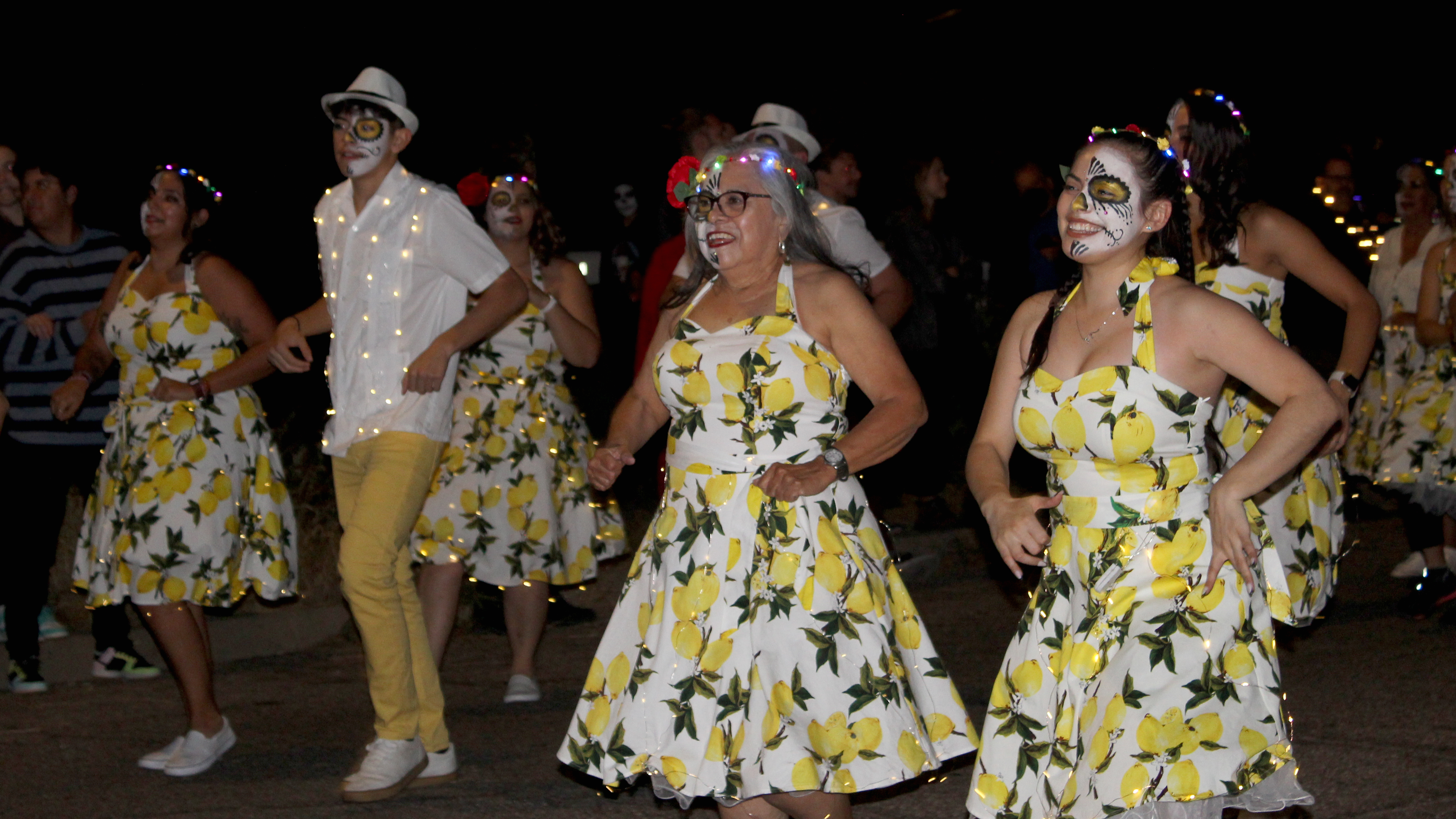 Salsa dancers walk in the annual All Souls Procession.