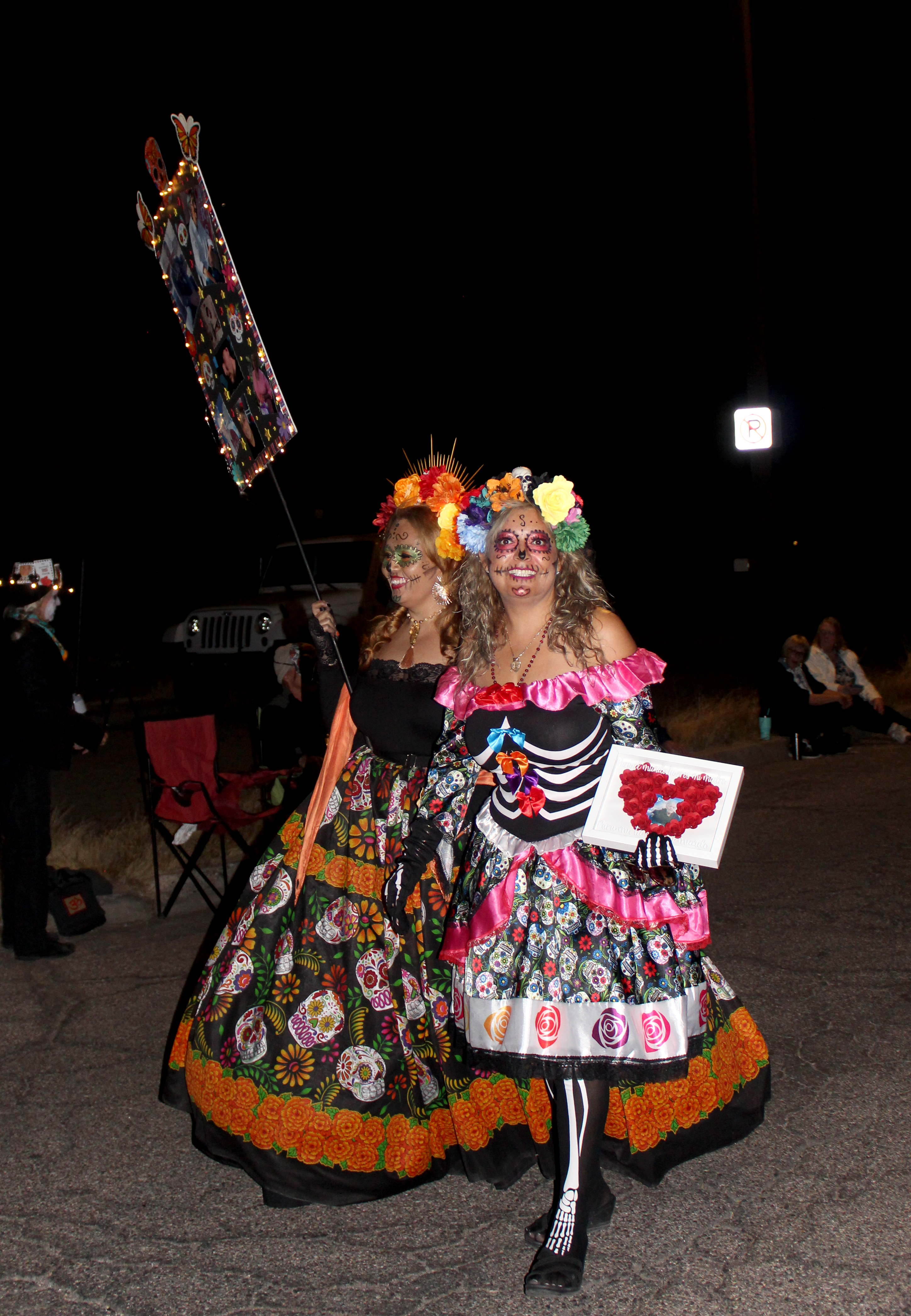 Two women walk down a street for the 33rd annual All Souls Procession.