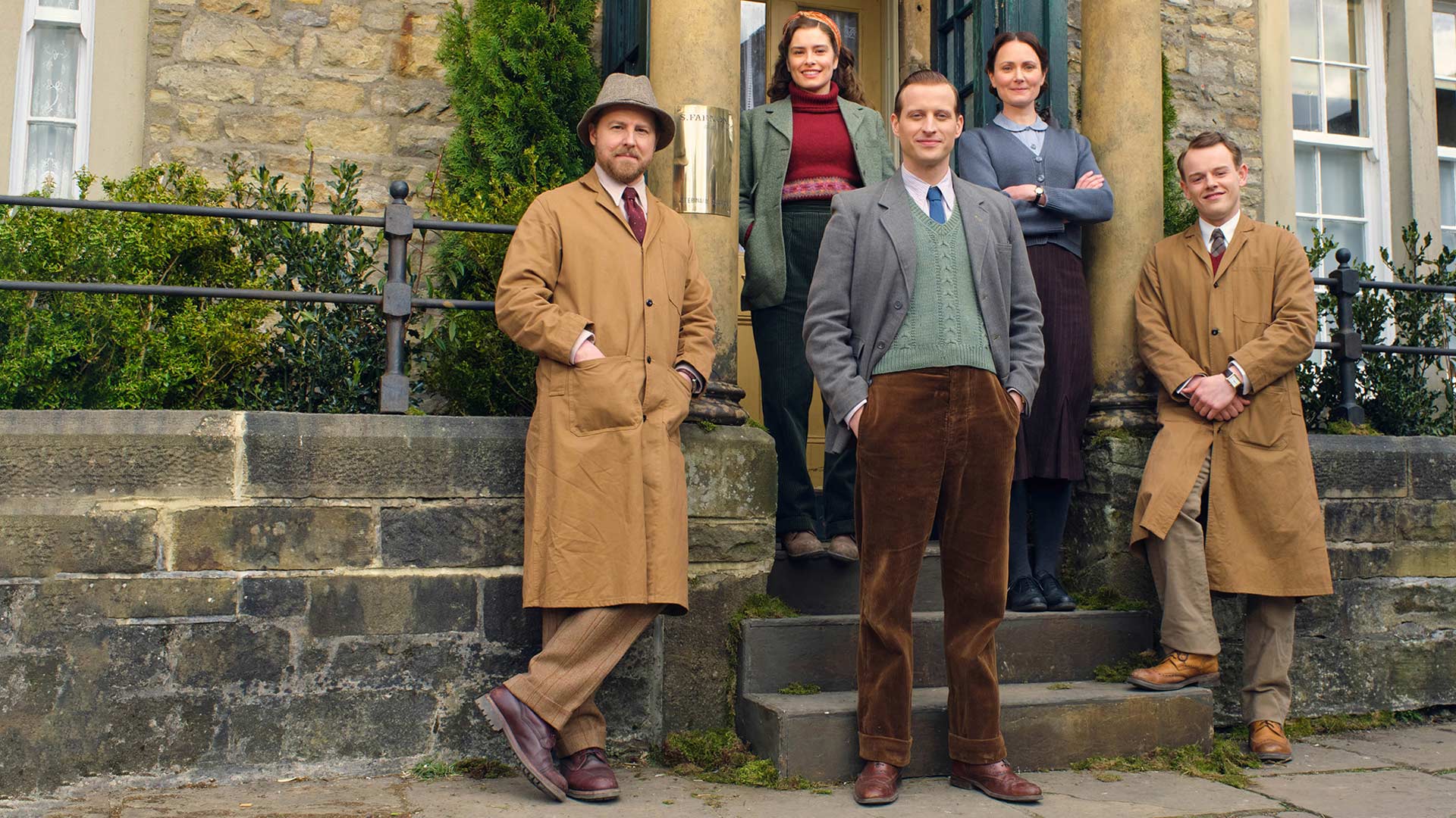 FRONT LEFT TO RIGHT: Siegfried Farnon (Samual West), James Herriot (Nicholas Ralph), & Tristan Farnon (Callum Woodhouse). BACK ROW: Helen Aladerson (Rachel Shenton) & Mrs. Hall (Anna Madeley)