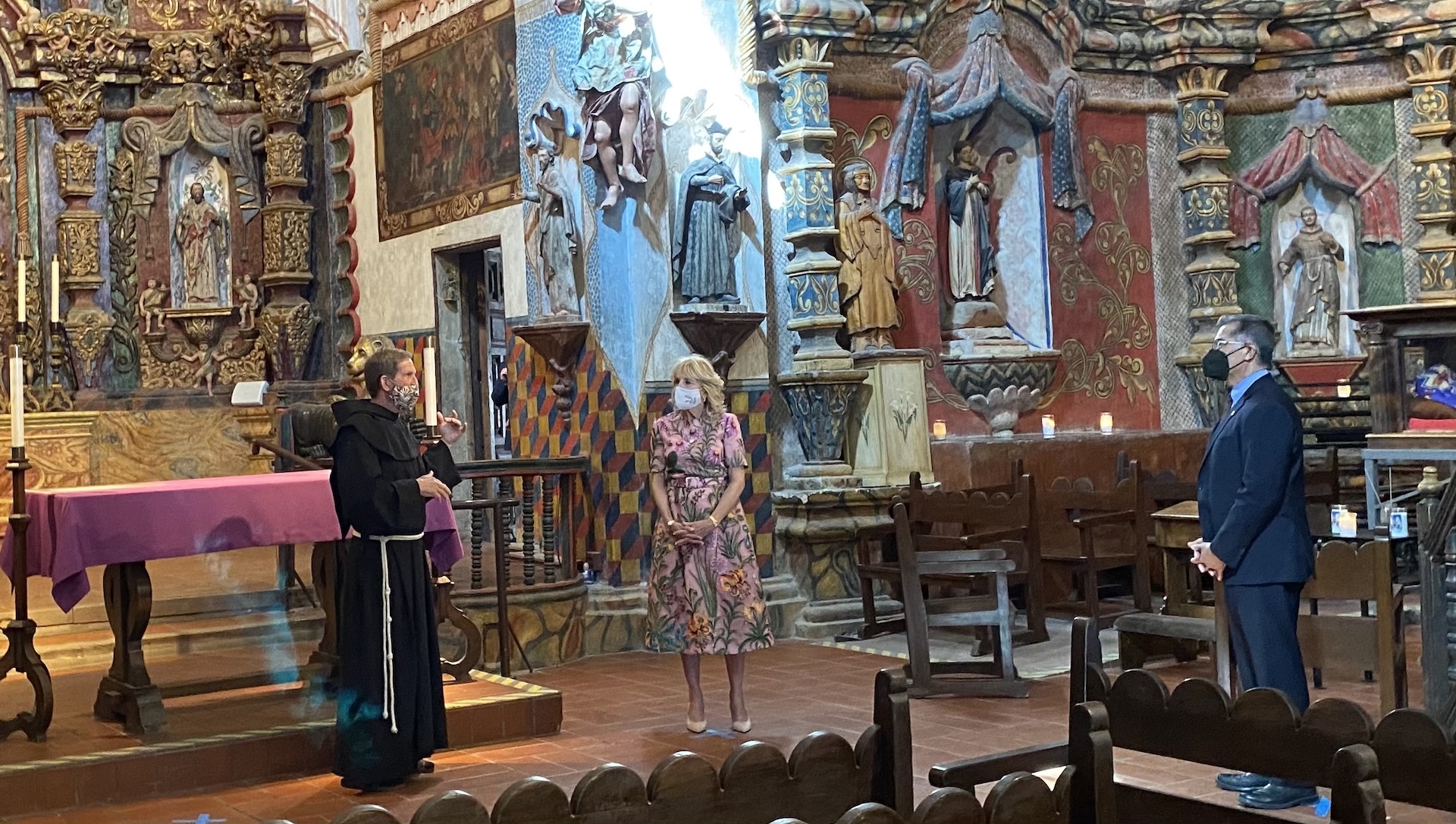 First Lady Jill Biden, center, and Health and Human Services Secretary Xavier Becerra, right, talk with Father Bill Minkel at Mission San Xavier del Bac on March 8, 2022.
