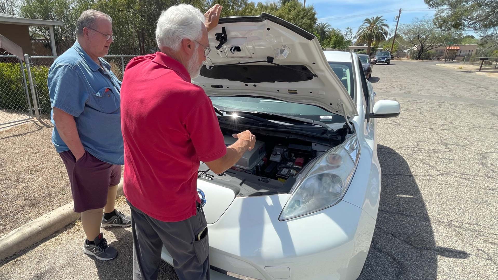 Rush Dougherty looks on as Leaf owner David Gebert checks out his electric car.  Both men are members of TEVA, the Tucson Electric Vehicle Association. 
