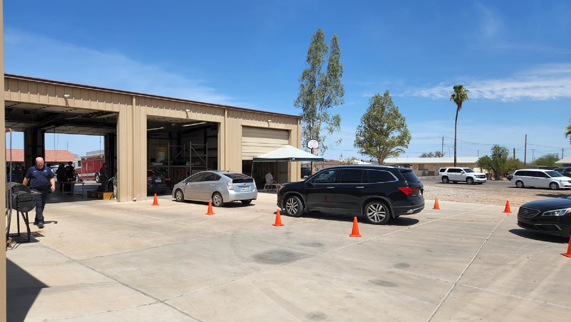 Residents of Eloy, northwest of Tucson, line up at Eloy Fire District Station #2 to receive ice and dry ice provided by Arizona Public Service.  More than 7,000 customers lost power when powerful monsoon winds blew down electrical lines Sunday night.