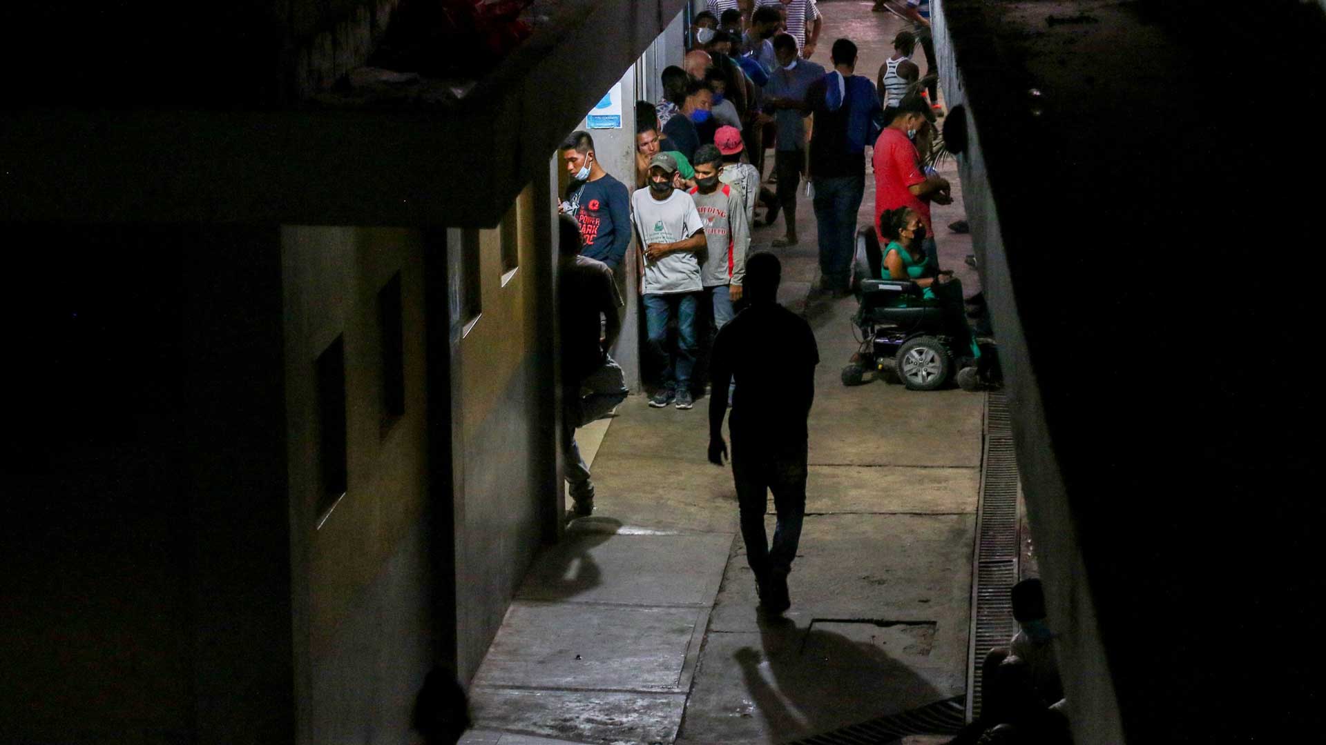 Migrants staying at Jesús el Buen Pastor, a migrant shelter in Tapachula, Mexico, line up for a free meal of black beans and tortillas on March 8, 2022. Guests are not allowed to bring food or drinks into the shelter and can’t take meals to go. Although migrants here have a roof, free meals and a mat or bed to sleep on, they must follow certain rules to stay.