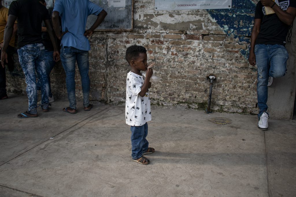 A young boy lines up with his family outside the refugee assistance office in Tapachula, Mexico, on March 9, 2022. Later in the day, a protest erupted outside the office, with dozens of migrants demanding their paperwork be expedited.