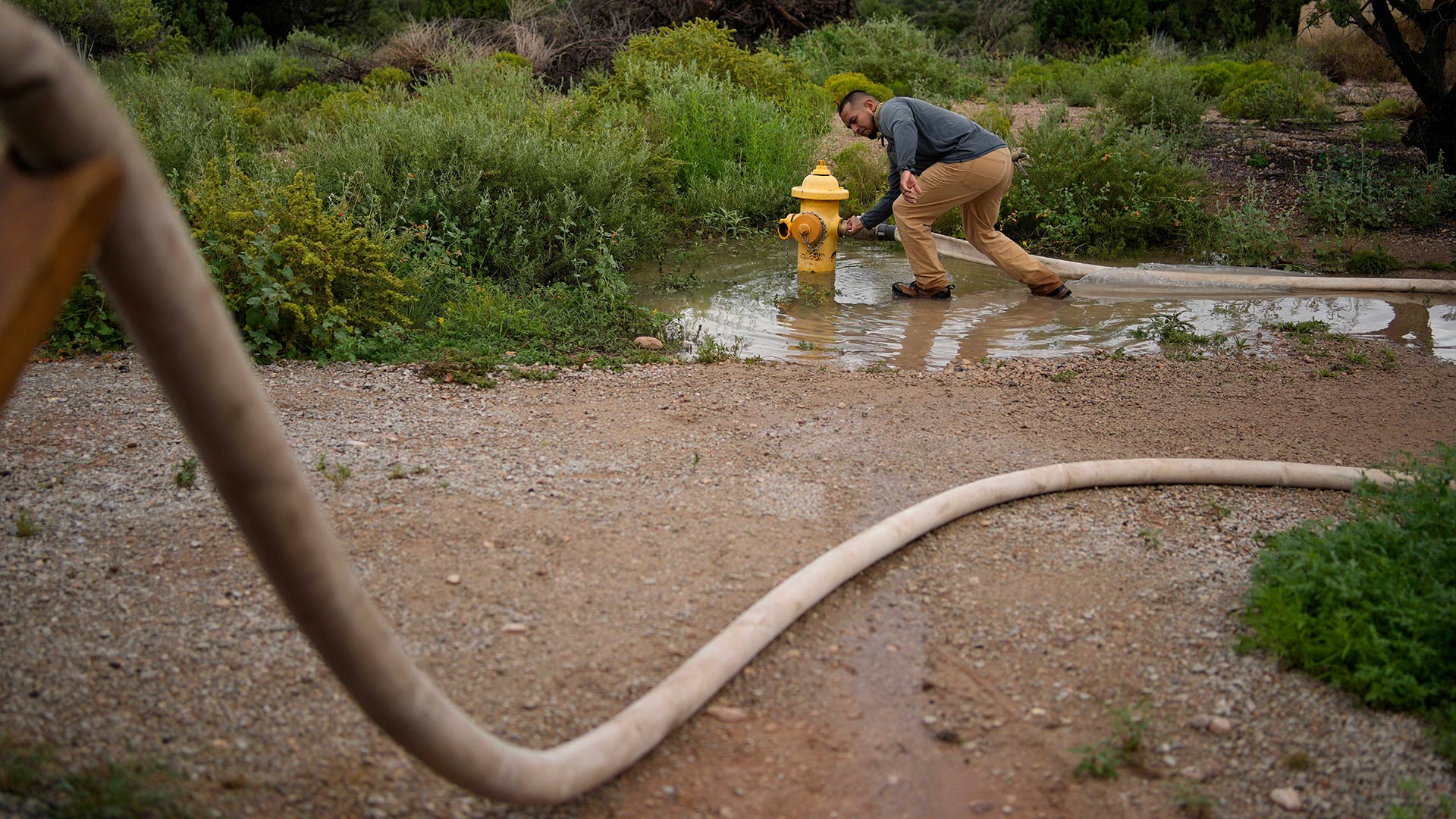 Garnett Querta fills his water truck from a fire hydrant on the Hualapai reservation Monday, Aug. 15, 2022, in Peach Springs, Ariz. The water pulled from the ground here will be piped dozens of miles across the rugged landscape to serve the roughly 600,000 tourists a year who visit the Grand Canyon on the Hualapai reservation in northwestern Arizona — an operation that's the tribe's main source of revenue.