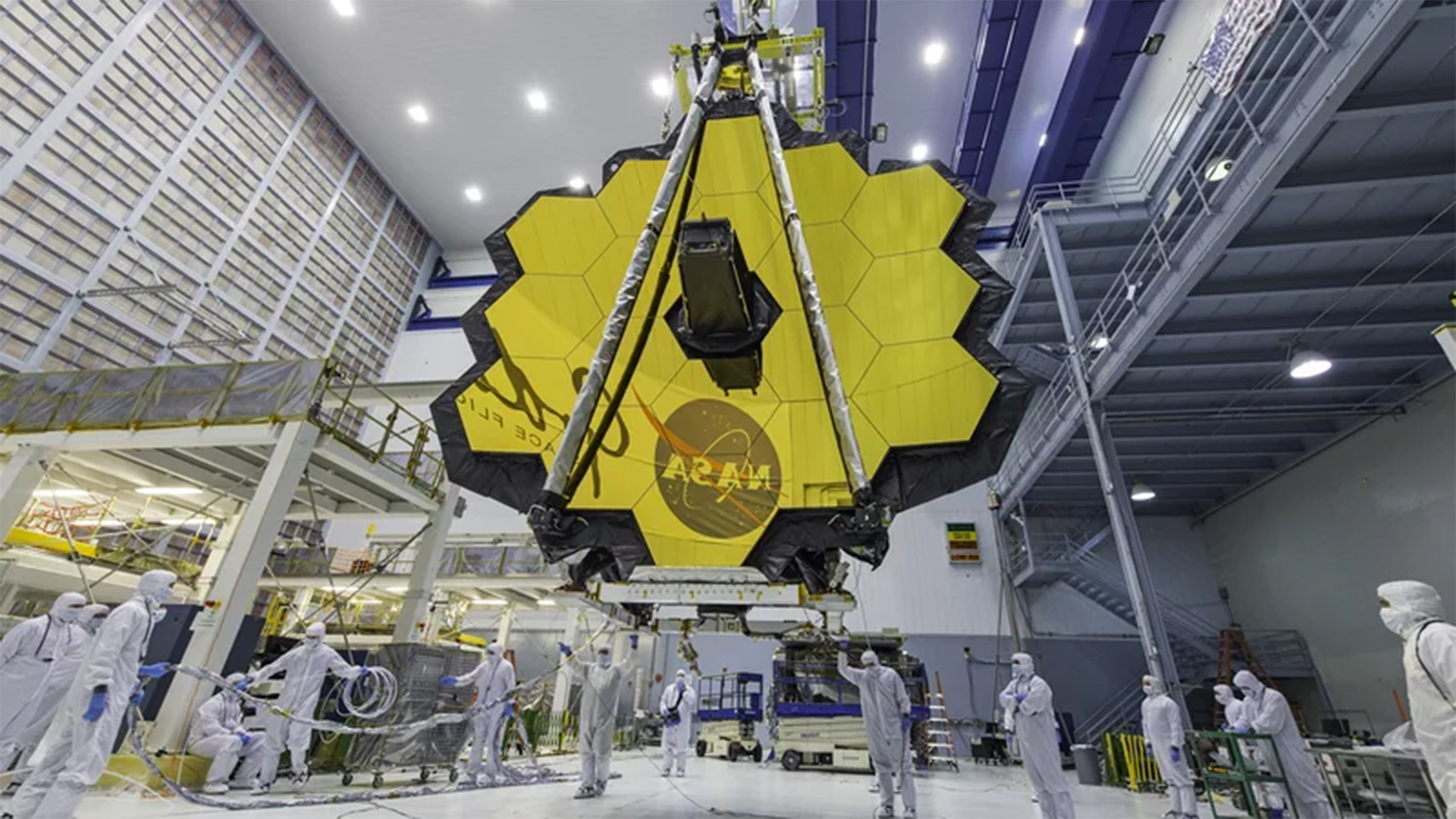 In this April 13, 2017 photo provided by NASA, technicians lift the mirror of the James Webb Space Telescope using a crane at the Goddard Space Flight Center in Greenbelt, Md. The telescope is designed to peer back so far that scientists will get a glimpse of the dawn of the universe about 13.7 billion years ago and zoom in on closer cosmic objects with sharper focus.