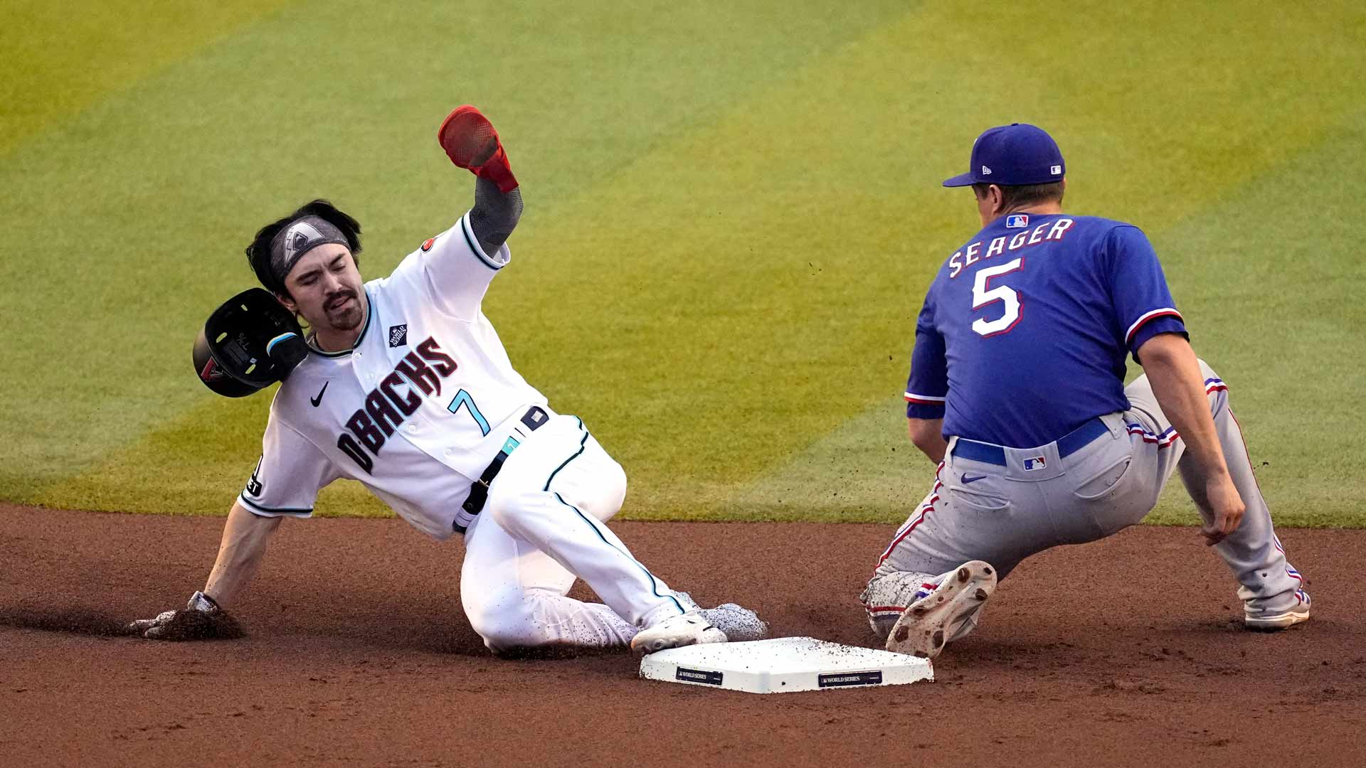 Arizona Diamondbacks' Corbin Carroll (7) steals second base as Texas Rangers shortstop Corey Seager (5) reaches to tag him during the first inning in Game 5 of the baseball World Series Wednesday, Nov. 1, 2023, in Phoenix. 