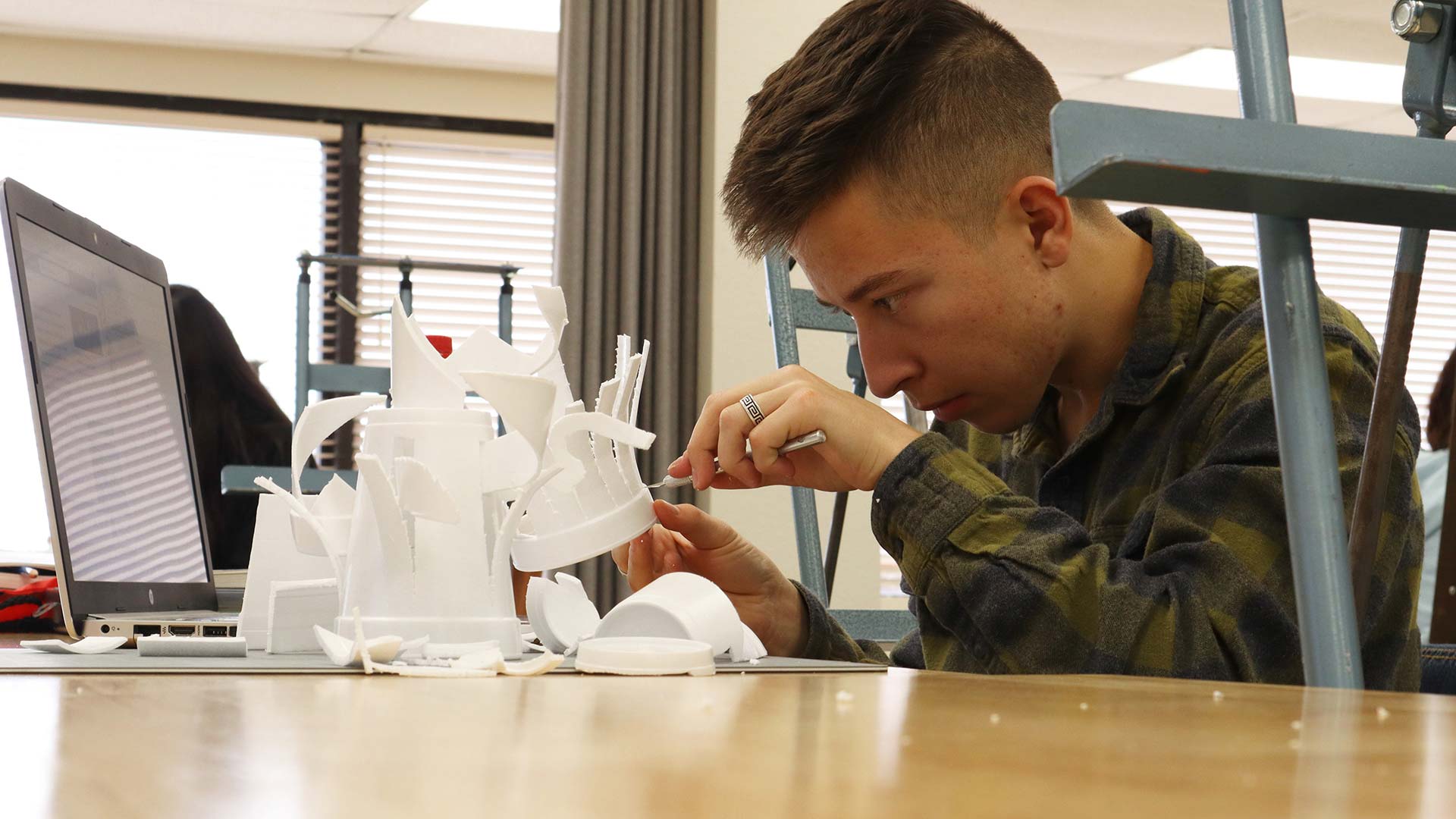 Cochise College Student Ethan Rodriguez works on a styrofoam sculpture during his art class with Art Instructor JenMarie Zeleznak.
