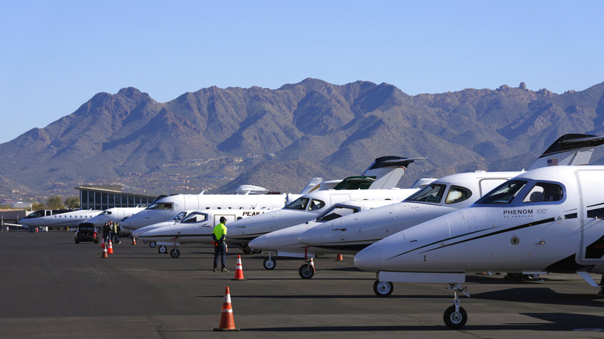 A Scottsdale Airport staffer waits on a private jet, as the airport gears up for the expected dramactic increase in private jet traffic, leading up to the NFL Super Bowl LVII football game